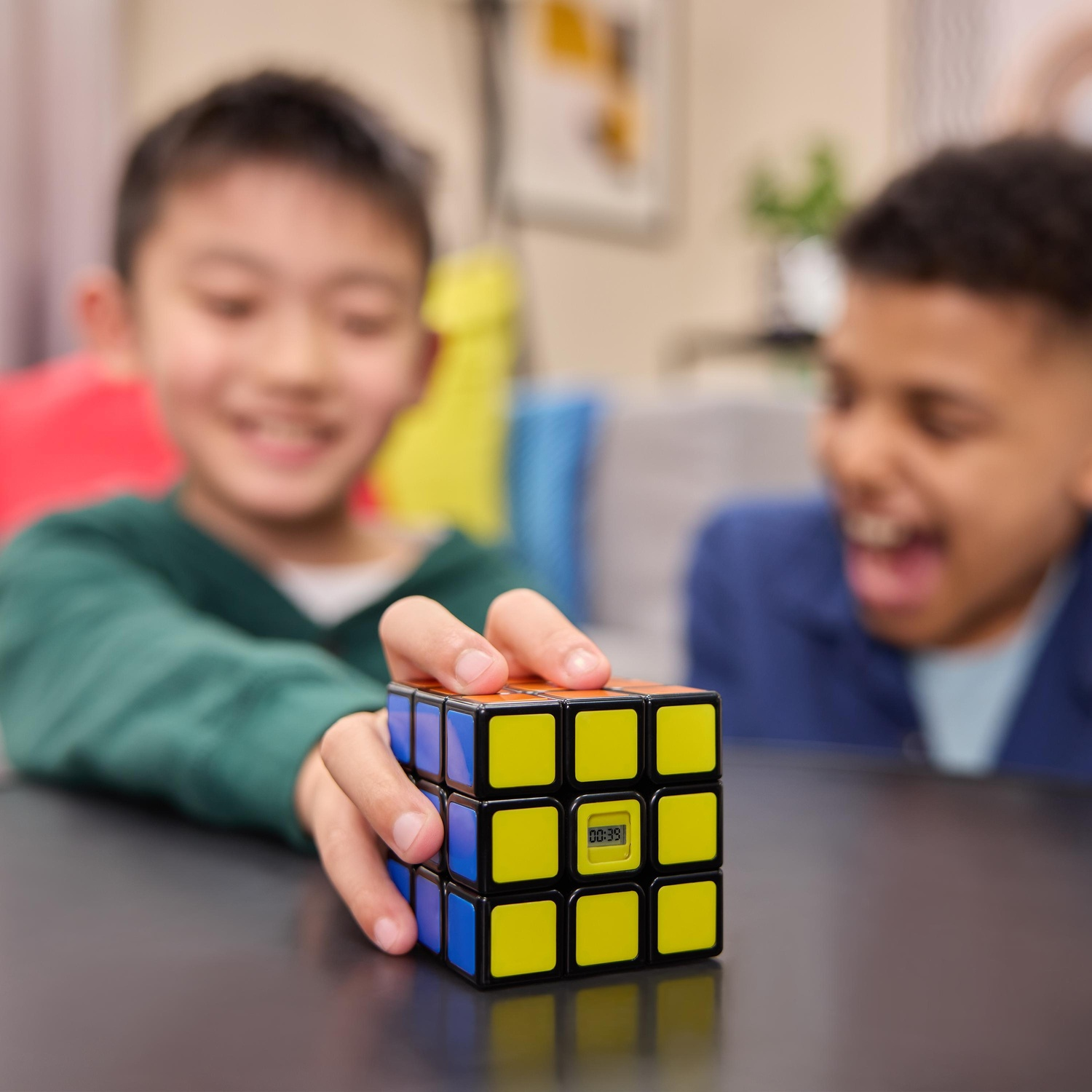 Due ragazzi sorridenti, uno che tiene un cubo di Rubik con un timer. Il cubo ha quadrati gialli, blu, arancioni e neri.