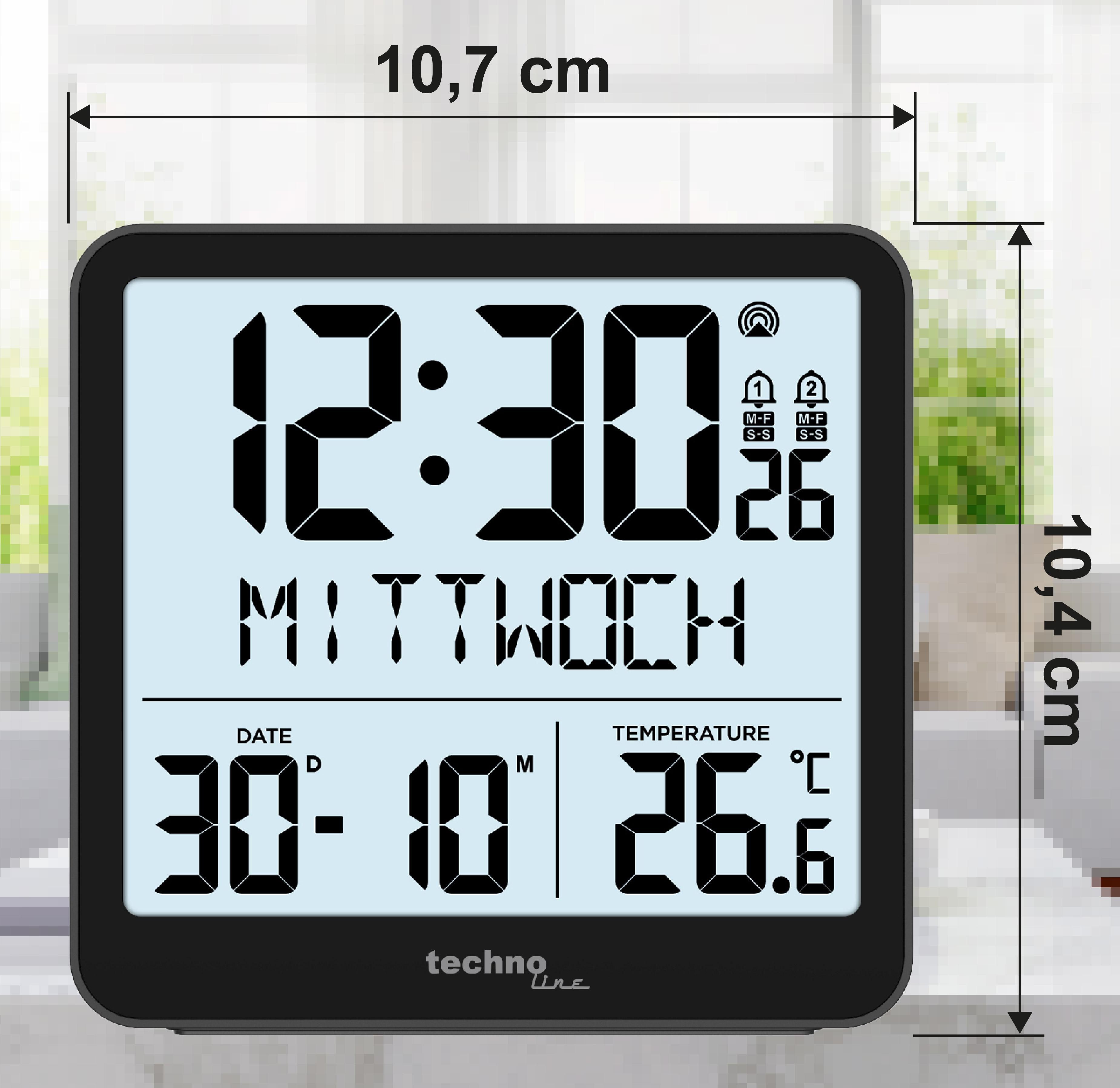Schwarze Digitaluhr mit Zeit-, Datums- und Temperaturanzeige. Hintergrund: ein Fenster mit verschwommener Sicht.