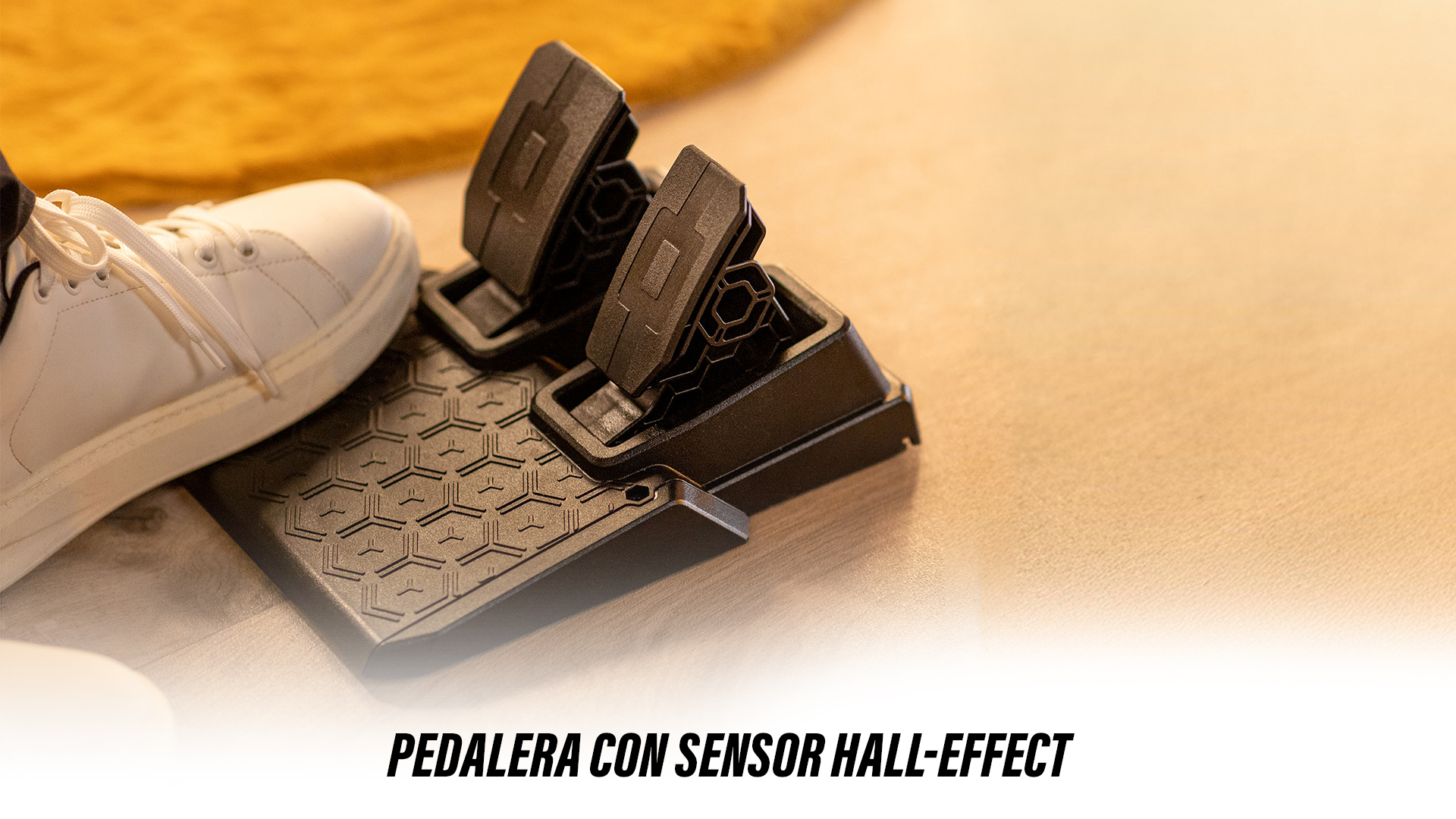 Pedales negros sobre una base estampada junto a un zapato blanco. El fondo es de color canela.