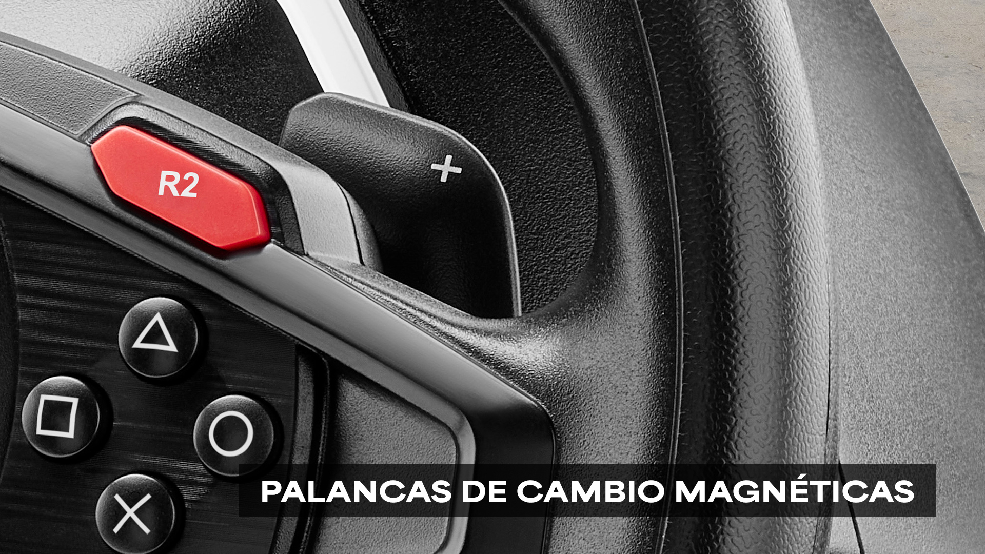 Primer plano de un volante negro con botón R2 rojo y botones con símbolos. Palancas de cambio magnéticas visibles.