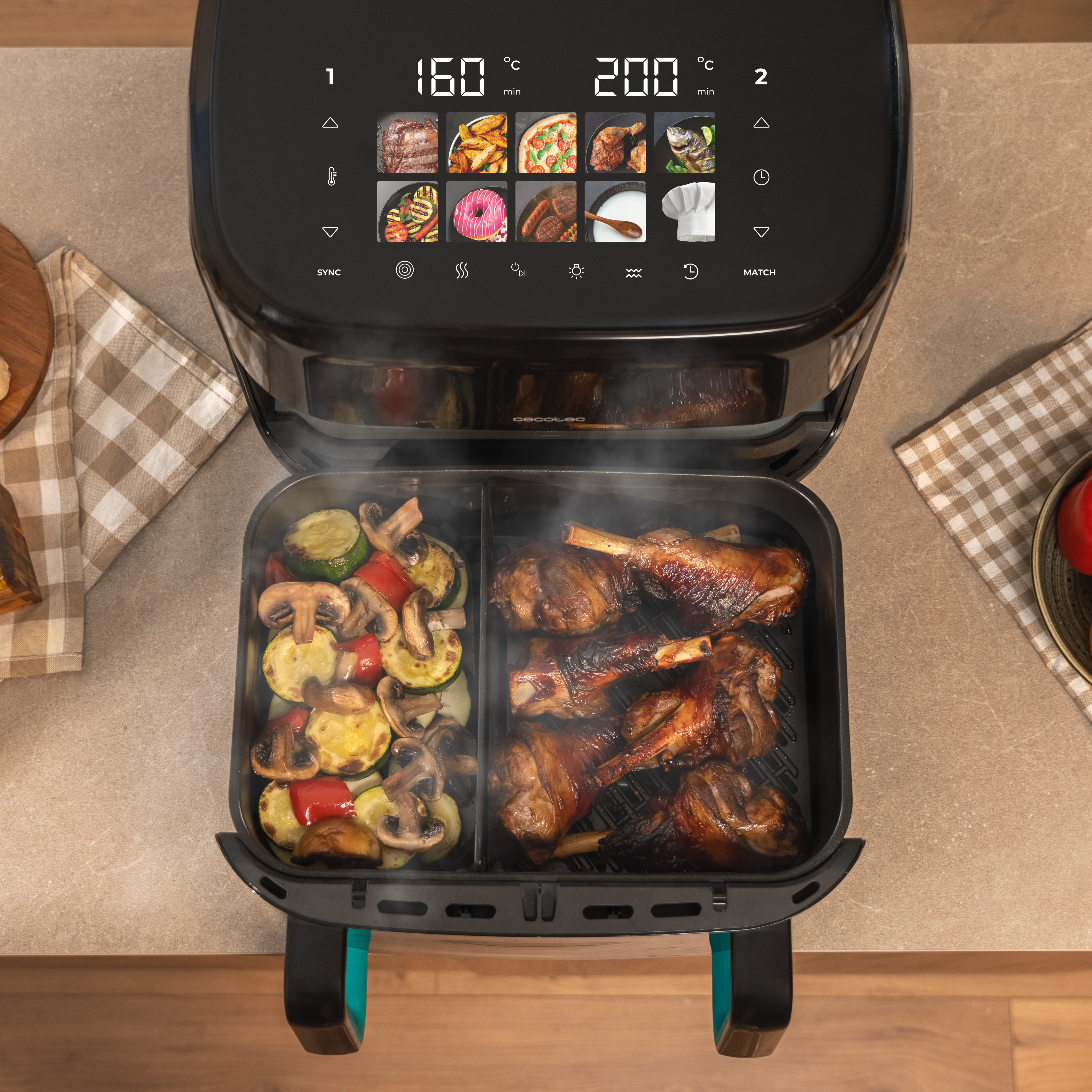 Una freidora de aire con verduras y carne asadas. La pantalla muestra la temperatura. Ambiente de cocina, vista aérea.
