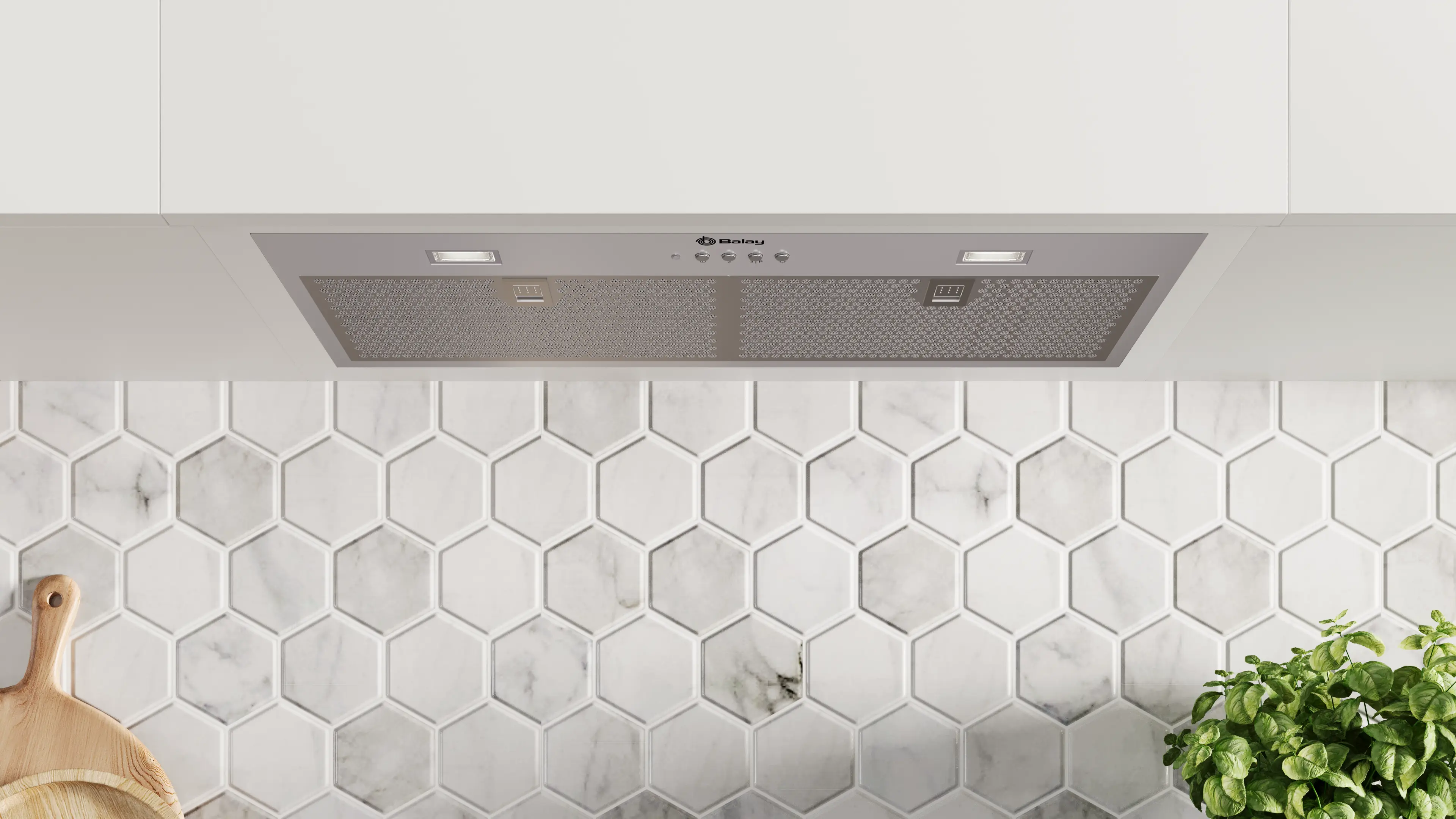 Una escena de cocina con una campana extractora Balay sobre un salpicadero de baldosas hexagonales. Una tabla de cortar de madera y una planta son visibles.