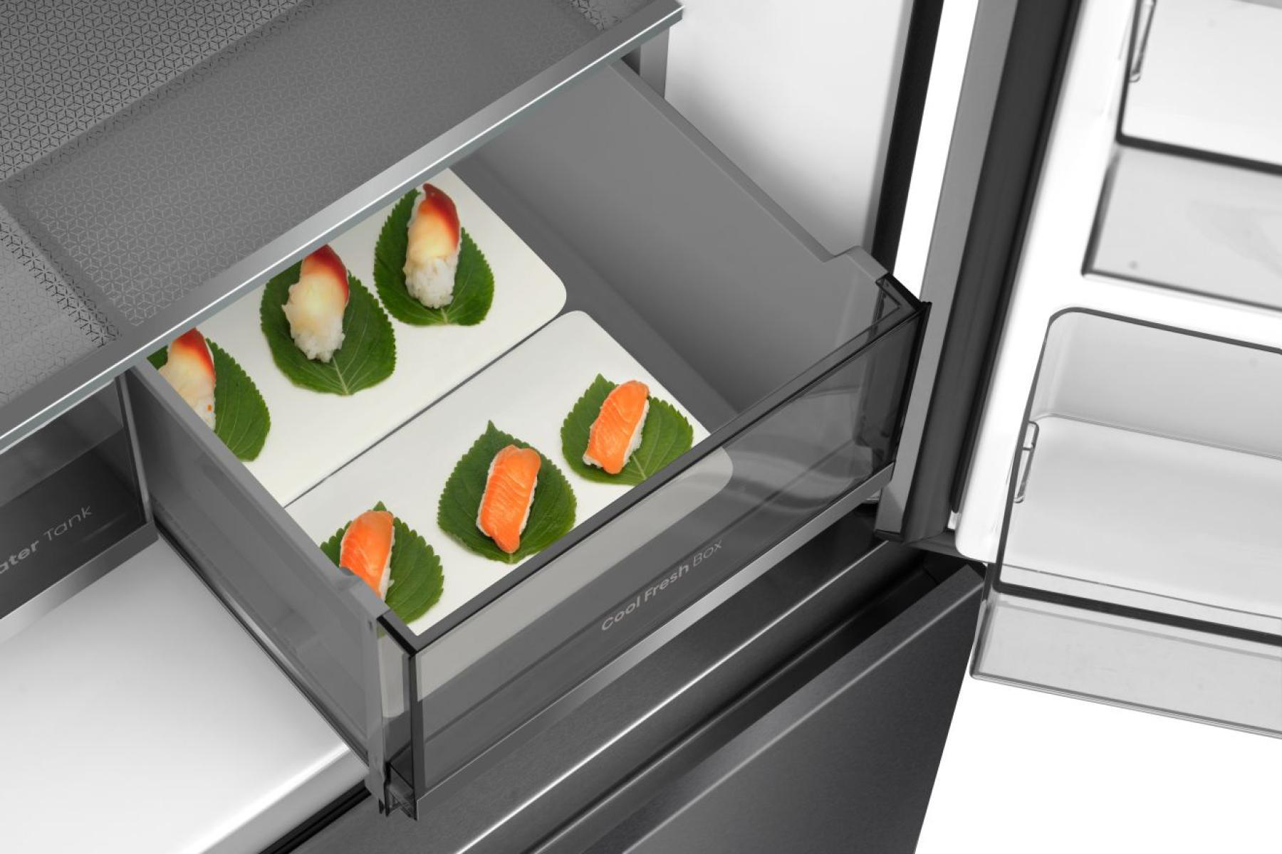 Sushi in einer Kühlschublade. Lachs- und Weißfisch-Nigiri auf grünen Blättern. Cool Fresh Box-Etikett sichtbar.