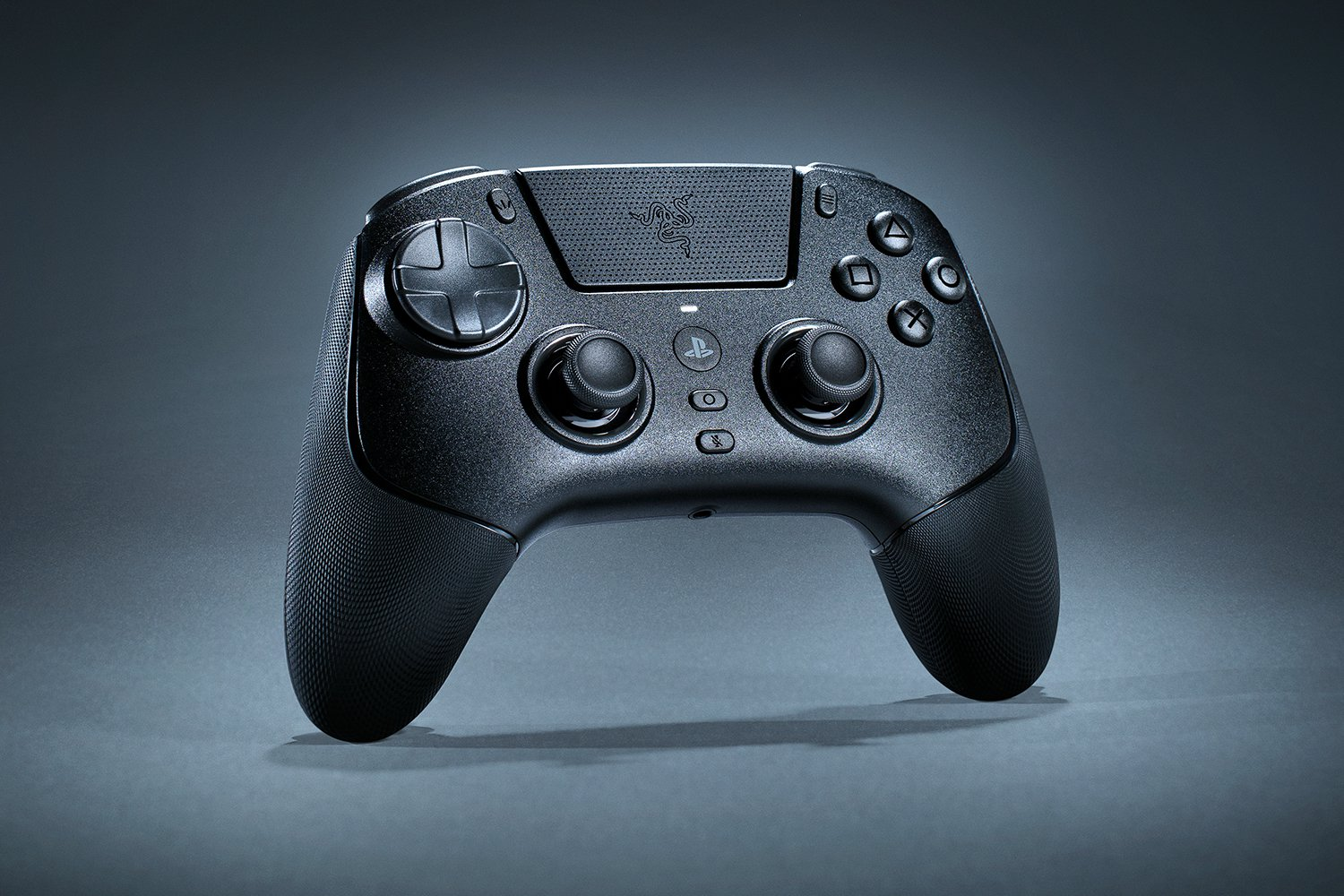 Schwarzer PlayStation-Controller auf grauem Untergrund. Er hat Knöpfe, Analogsticks und ein Razer-Logo. Der Hintergrund ist grau.