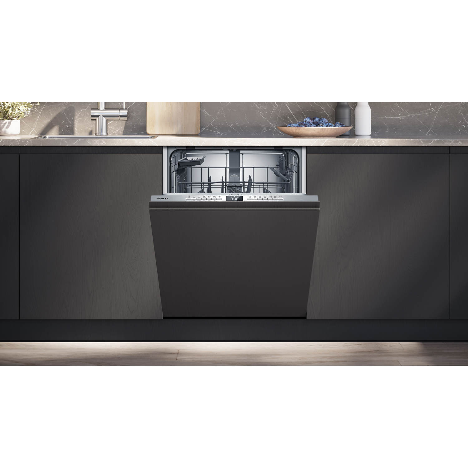 Open dishwasher in a modern kitchen. Dark cabinets, marble countertop, and a wooden cutting board are visible.