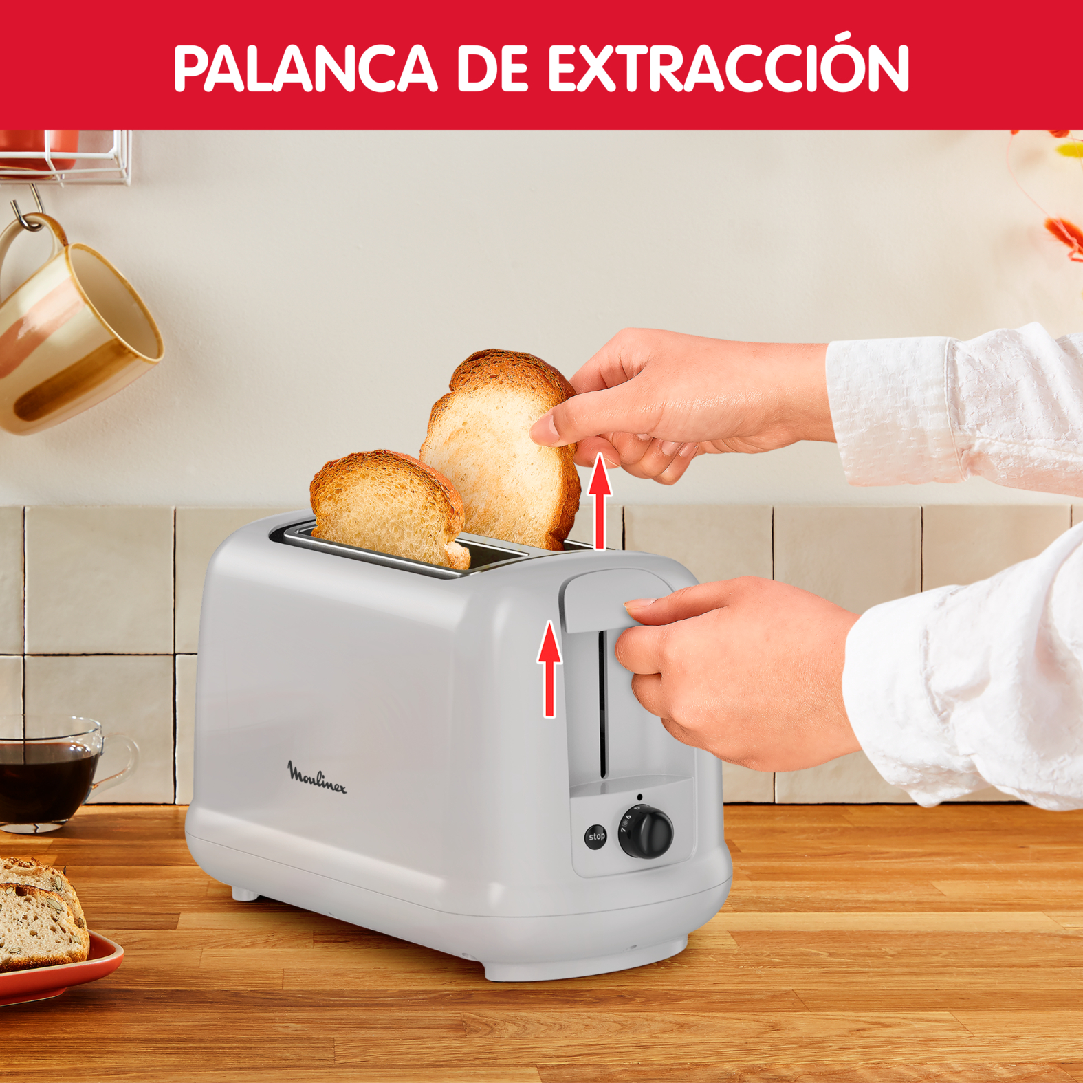 Una persona saca pan tostado de una tostadora Moulinex blanca. El pan es de color dorado.