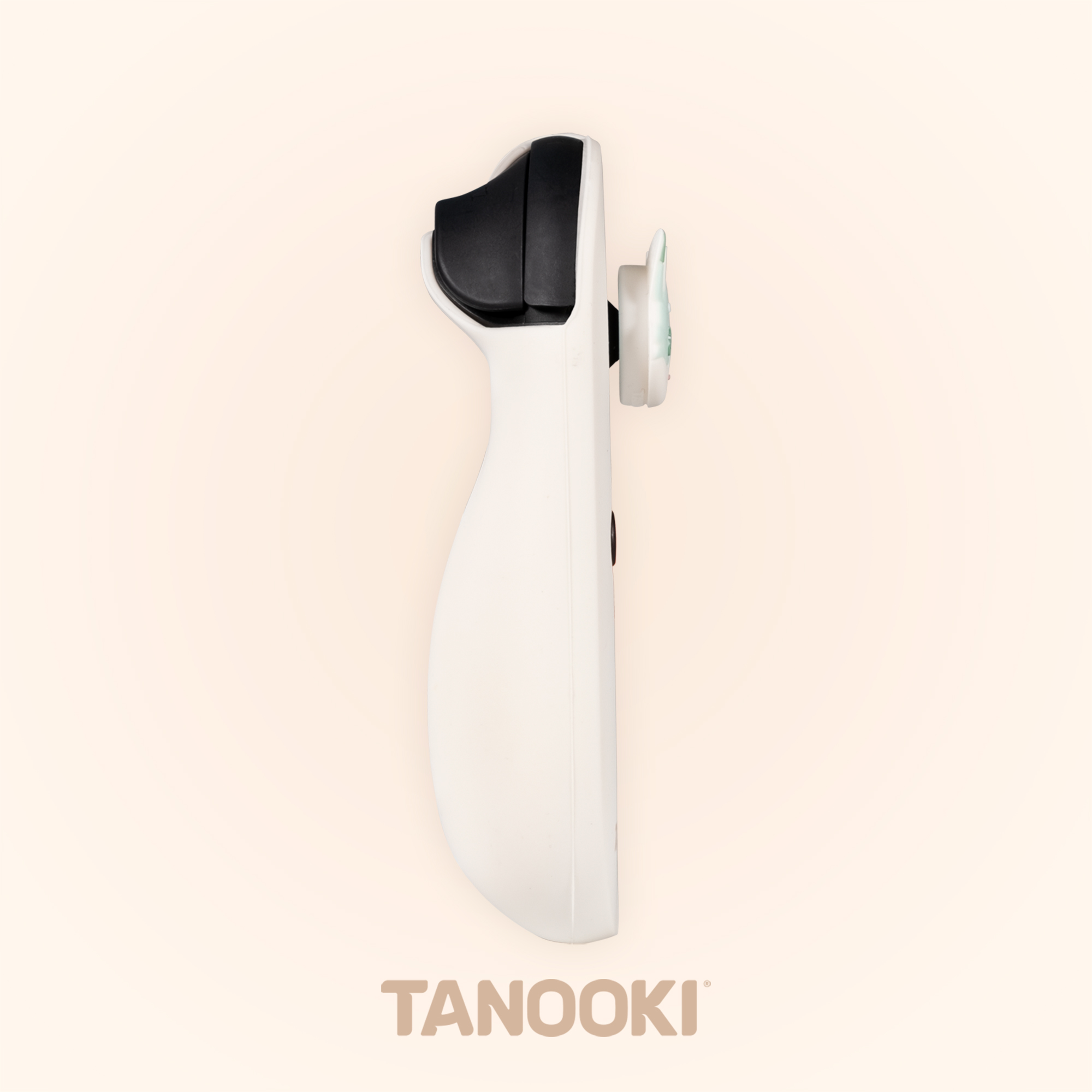 Un dispositivo blanco y negro se muestra sobre un fondo crema. La marca es Tanooki.