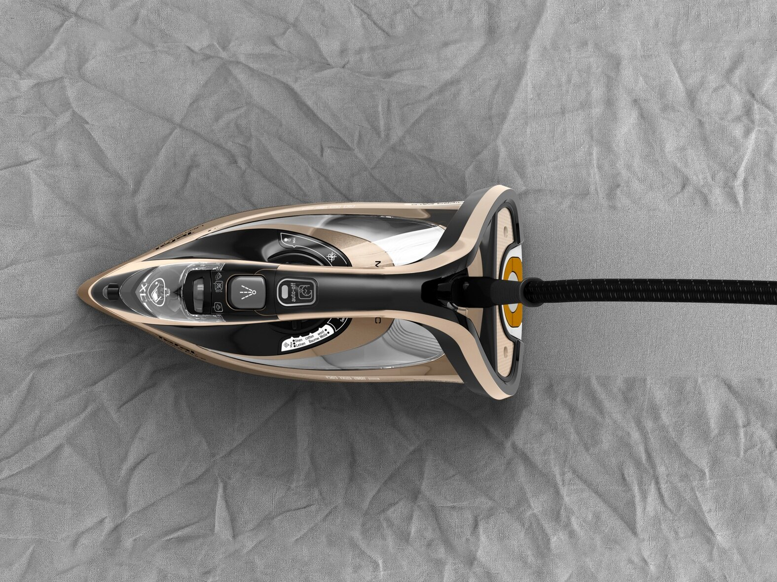 Beżowe i czarne żelazko na szarej, pogniecionej tkaninie. Żelazko ma przewód. Żelazko znajduje się na środku kadru.