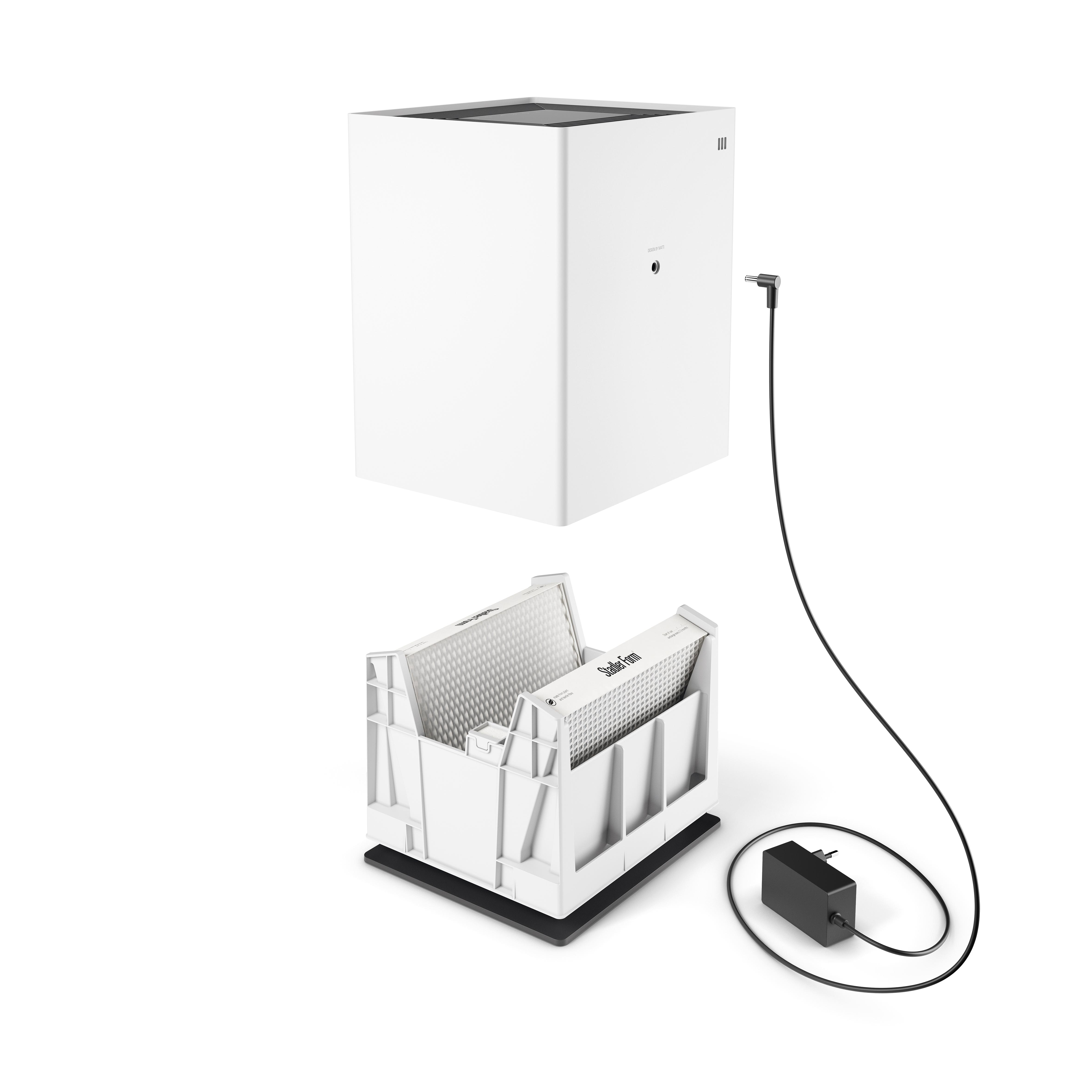 Ein weißer Luftreiniger, mit Filterfach, Netzteil und Kabel. Der Reiniger hat eine Würfelform.