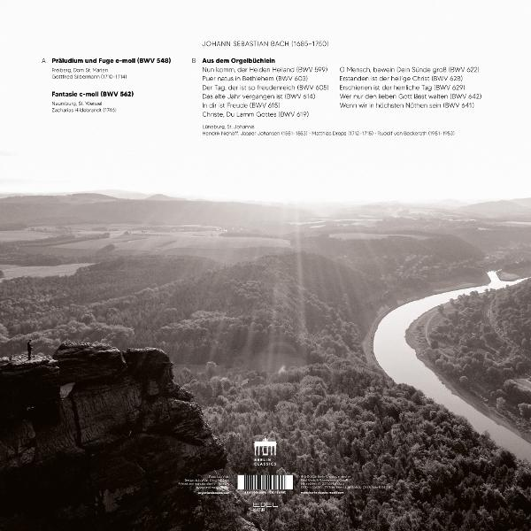 Monochrome Landschaft mit Fluss. Eine Person steht auf einem Felsen. Text oben und unten sichtbar.