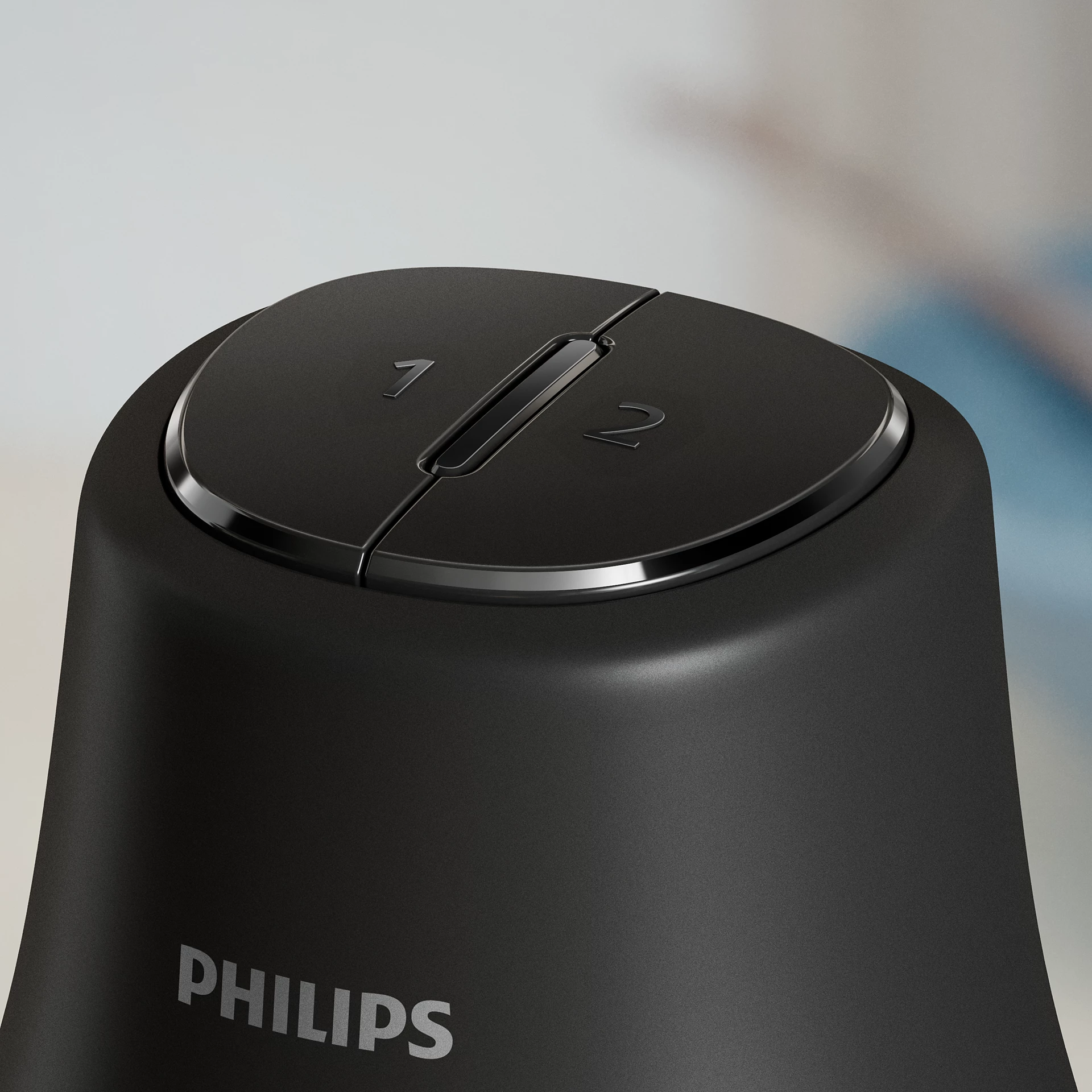Primer plano de un dispositivo Philips negro. Tiene una parte superior redonda con dos secciones. Los números 1 y 2 son visibles.