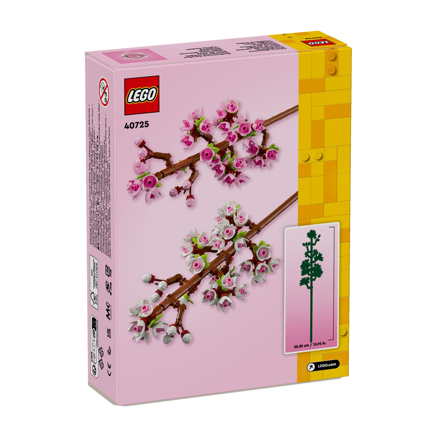Una scatola LEGO mostra rami di fiori di ciliegio con fiori rosa e bianchi. La scatola è rosa e gialla con il marchio LEGO.