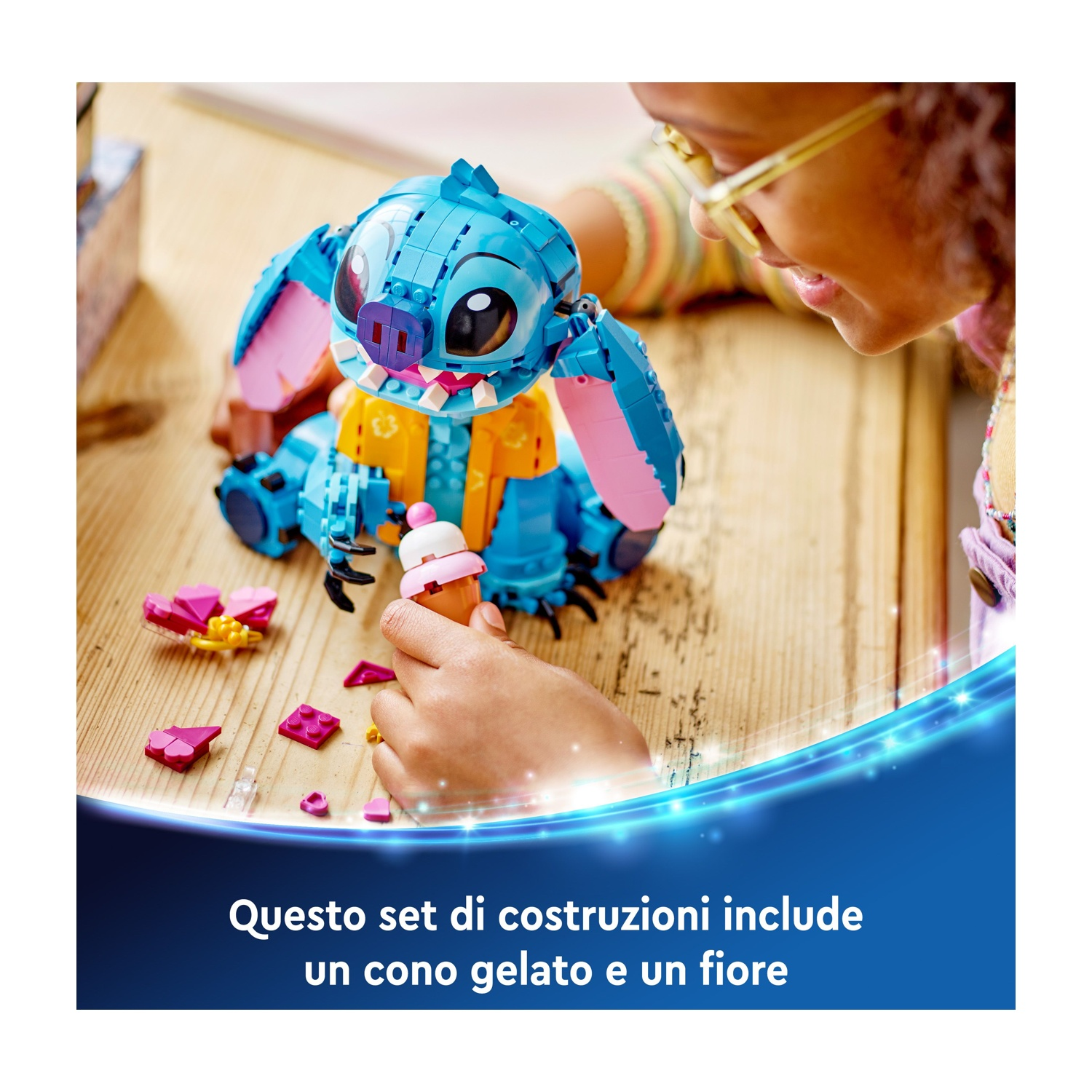 Un bambino gioca con un set Lego di Stitch, tenendo in mano un cono gelato. Il set è su una superficie di legno.