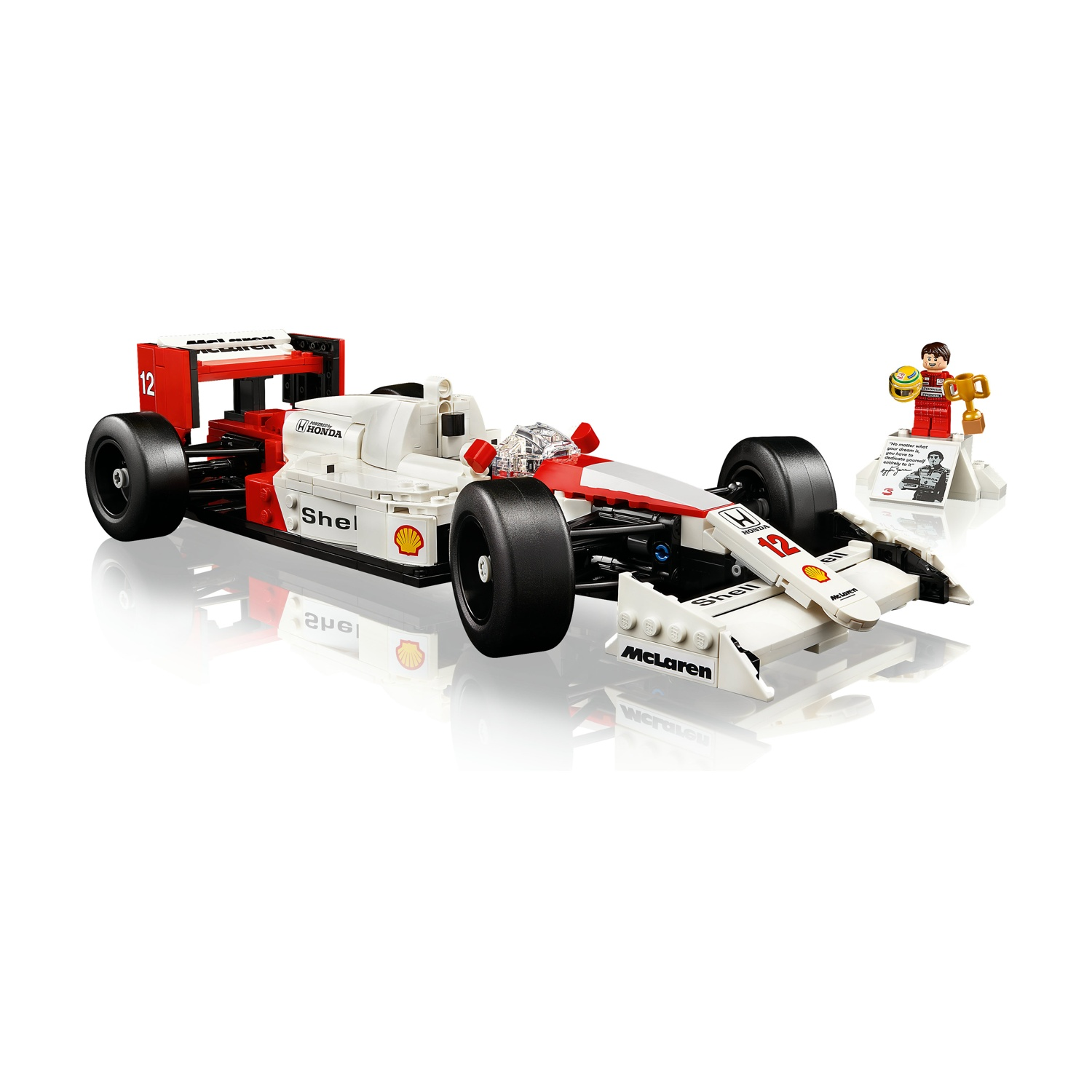Una macchina da corsa McLaren di Formula 1 Lego, bianca e rossa, con il numero 12. Una figurina Lego tiene un trofeo. Loghi Shell e Honda.
