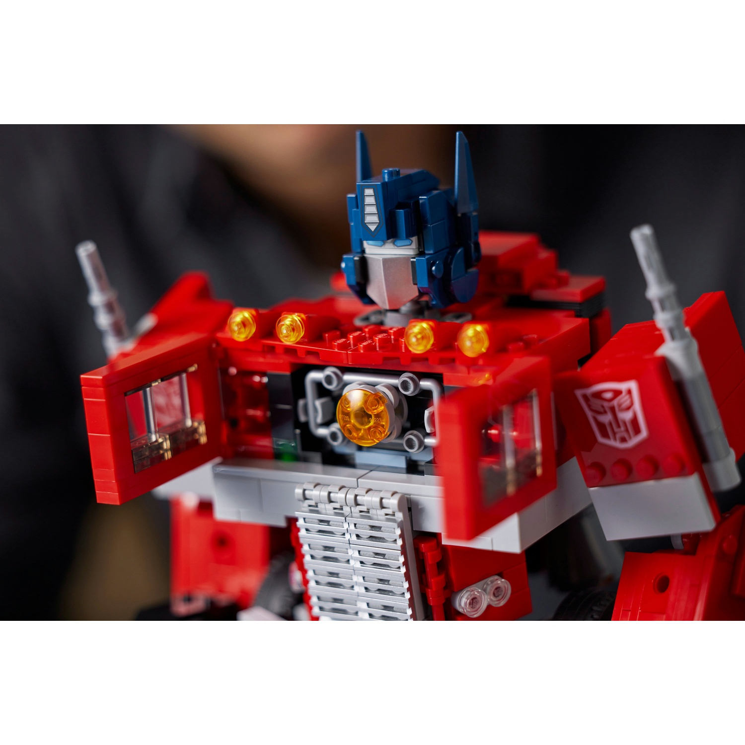 Primo piano di un Optimus Prime Lego rosso e blu. Dettagli includono la testa, un vano toracico e il simbolo Autobot.