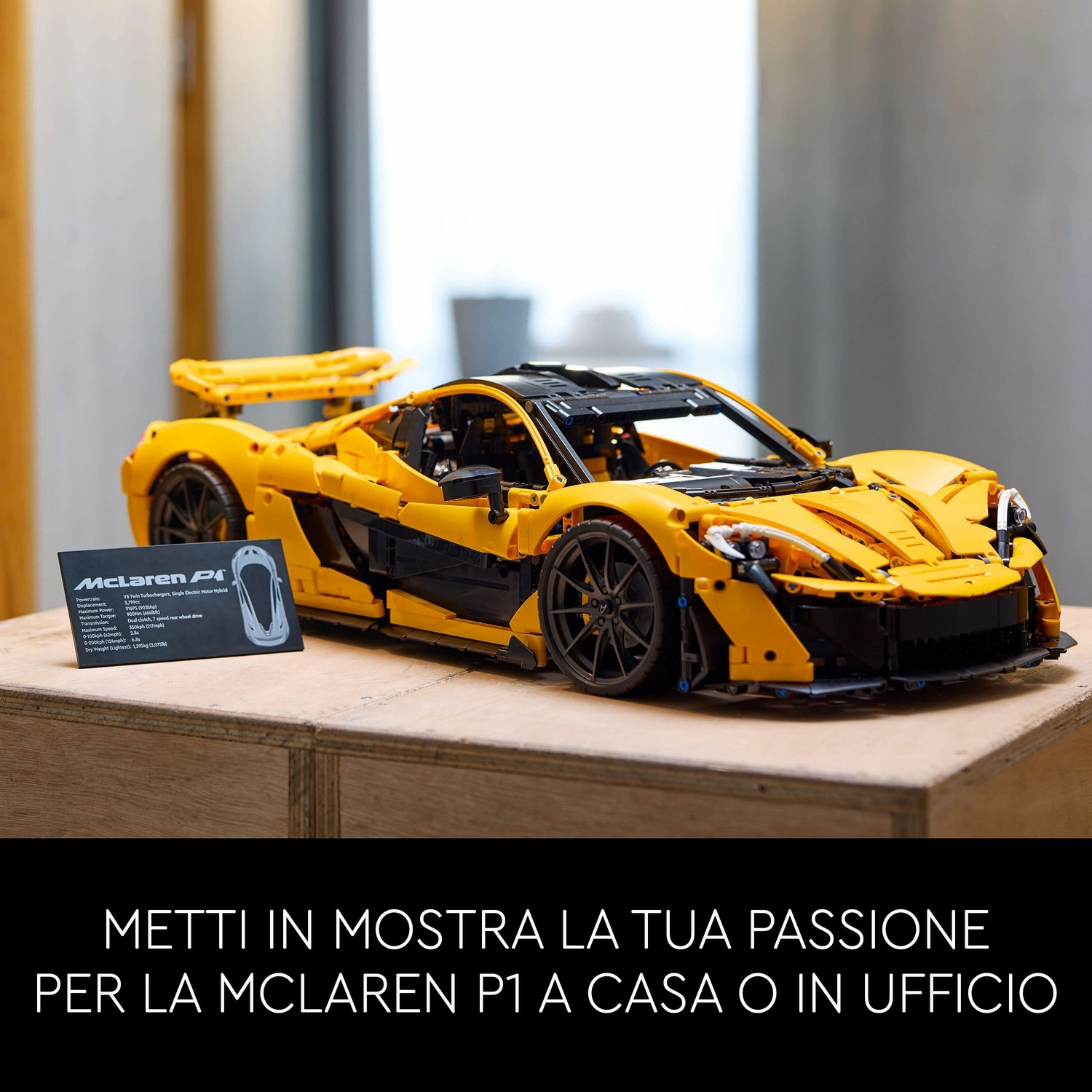 Un'auto modello McLaren P1 gialla e nera su una superficie di legno. Una scheda con le specifiche dell'auto è accanto.