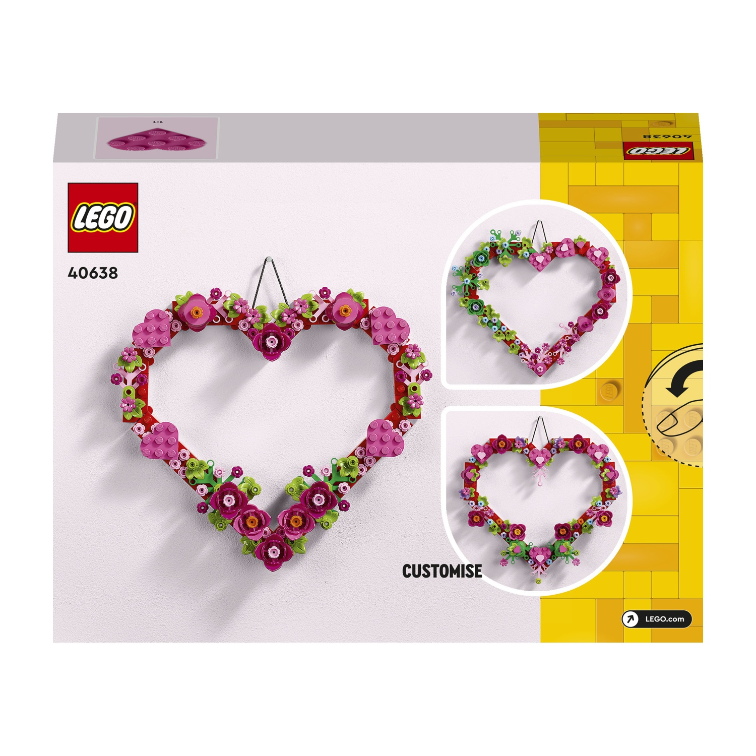 Una ghirlanda Lego a forma di cuore. È decorata con fiori rosa, rossi e verdi. Lo sfondo mostra un muro bianco e mattoncini Lego gialli.