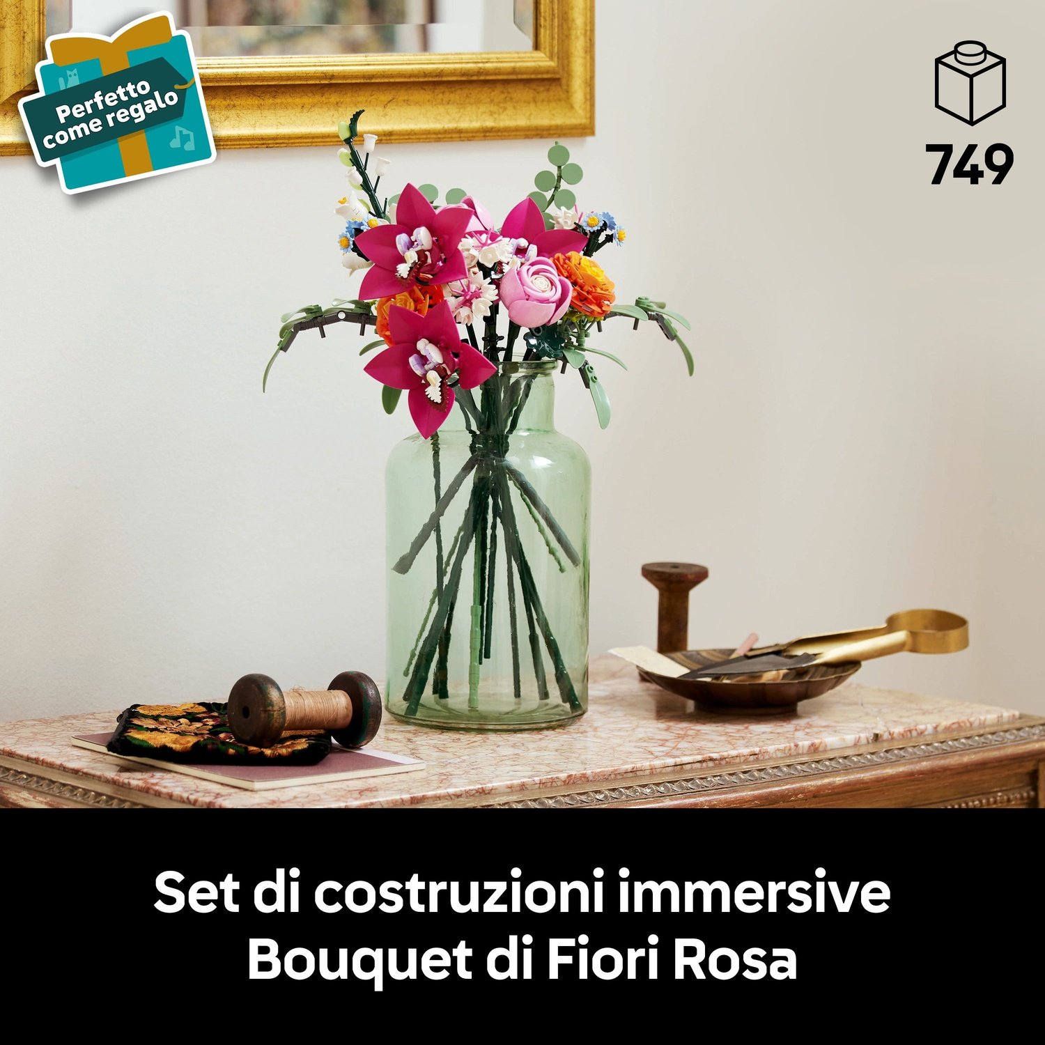 Un mazzo di fiori rosa e rossi in un vaso di vetro, posto su un tavolo con piano in marmo. Un'etichetta regalo è visibile.