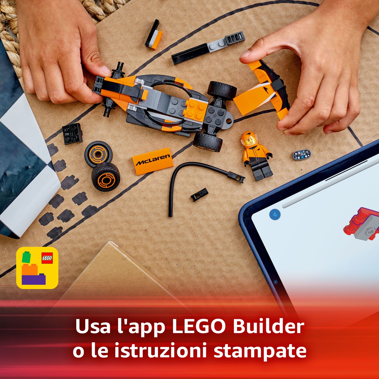 Mani che assemblano un'auto Lego McLaren. Parti sparse su una superficie di cartone. Include ruote, una mini-figura e un tablet.