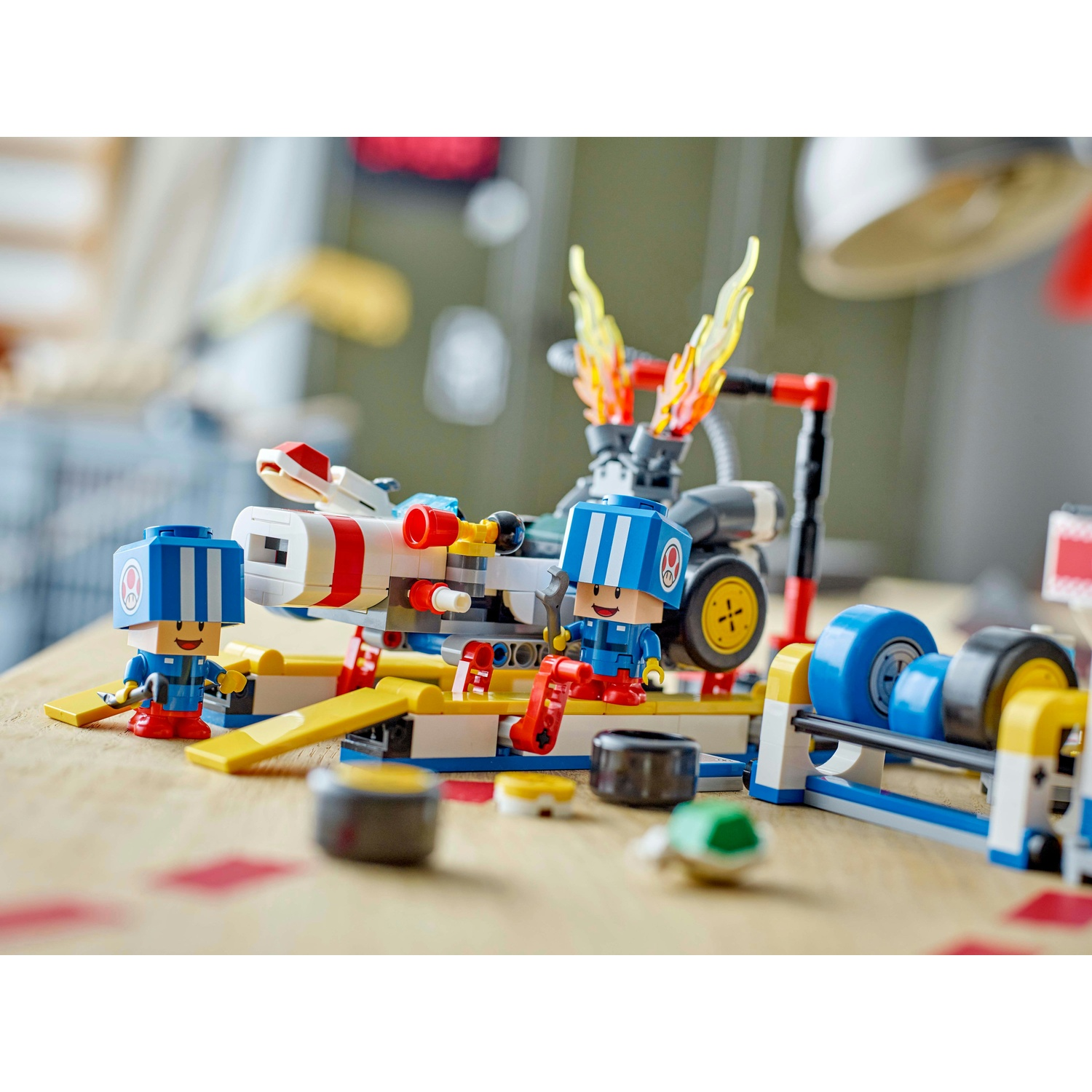 Set Lego con due personaggi, un razzo e un'officina. I personaggi sono blu e rossi e il razzo ha fiamme rosse.