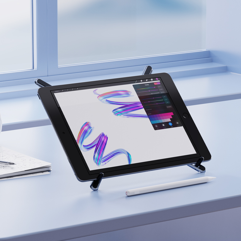 Bir stand üzerindeki bir iPad, renkli fırça darbeleri sergiliyor. Bir kalem ve not defteri masanın üzerinde. Arka plan bir pencere içeriyor.