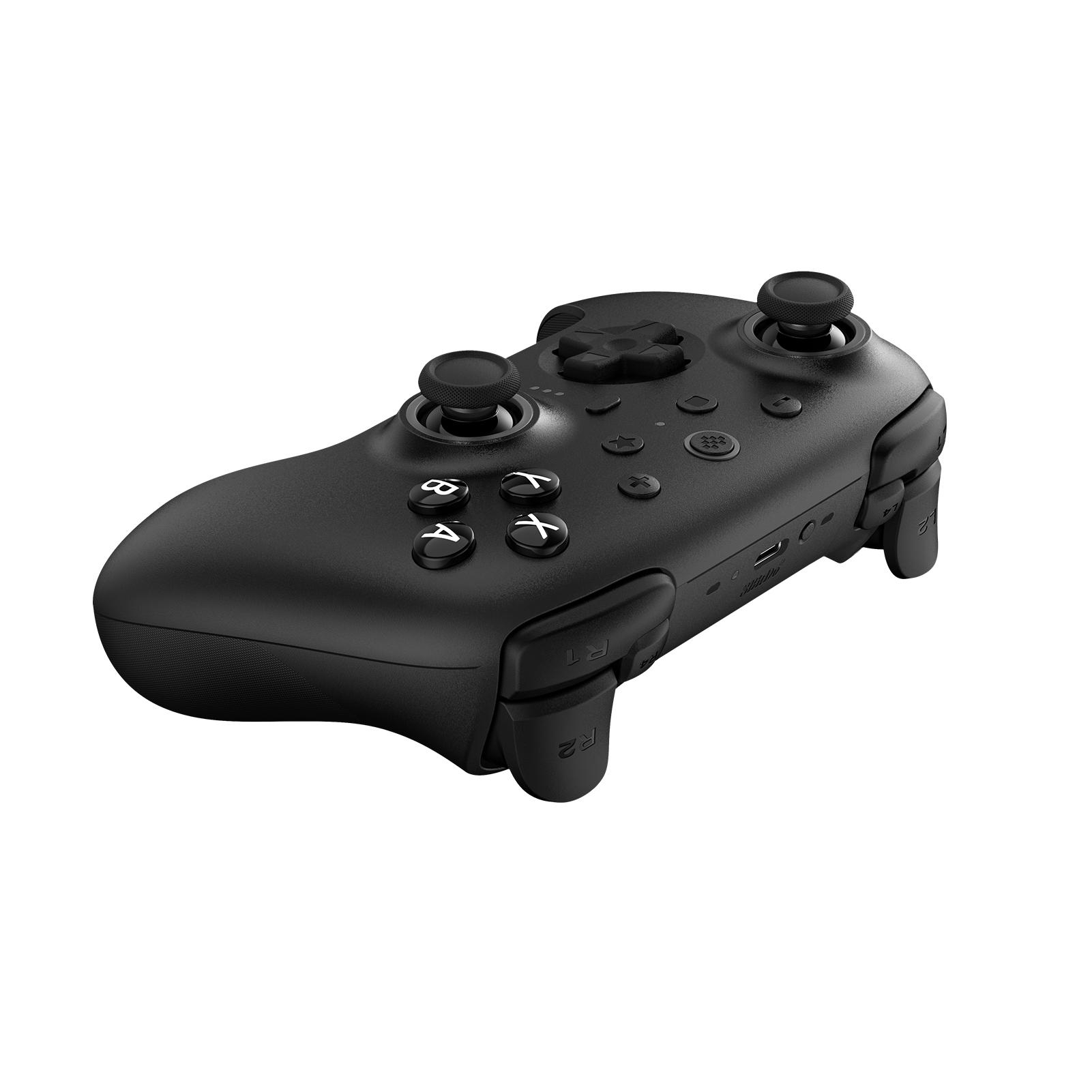 Ein schwarzes Gamepad mit Knöpfen und analogen Sticks liegt auf weißem Grund. Es ist ein Spiel-Controller.