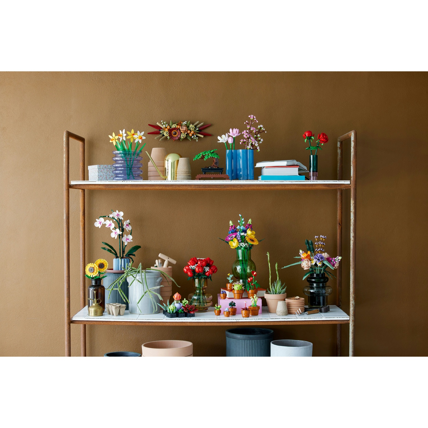 Una mensola espone vari set di fiori Lego, tra cui girasoli, rose, orchidee e altre composizioni colorate in vasi e vasi.