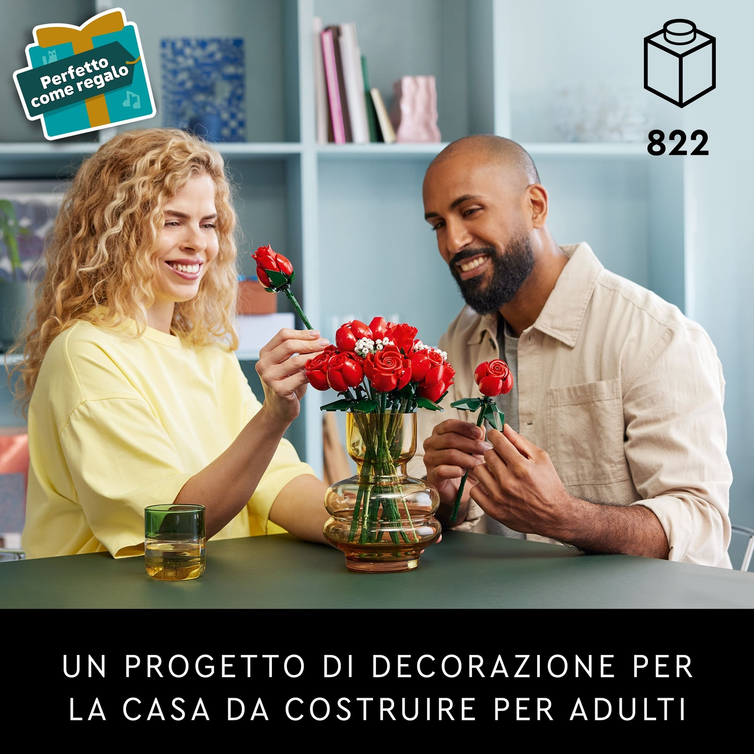 Una coppia sorride, sistemando fiori Lego a forma di rose rosse. Un'etichetta regalo è in alto a sinistra. Il numero 822 in alto a destra.