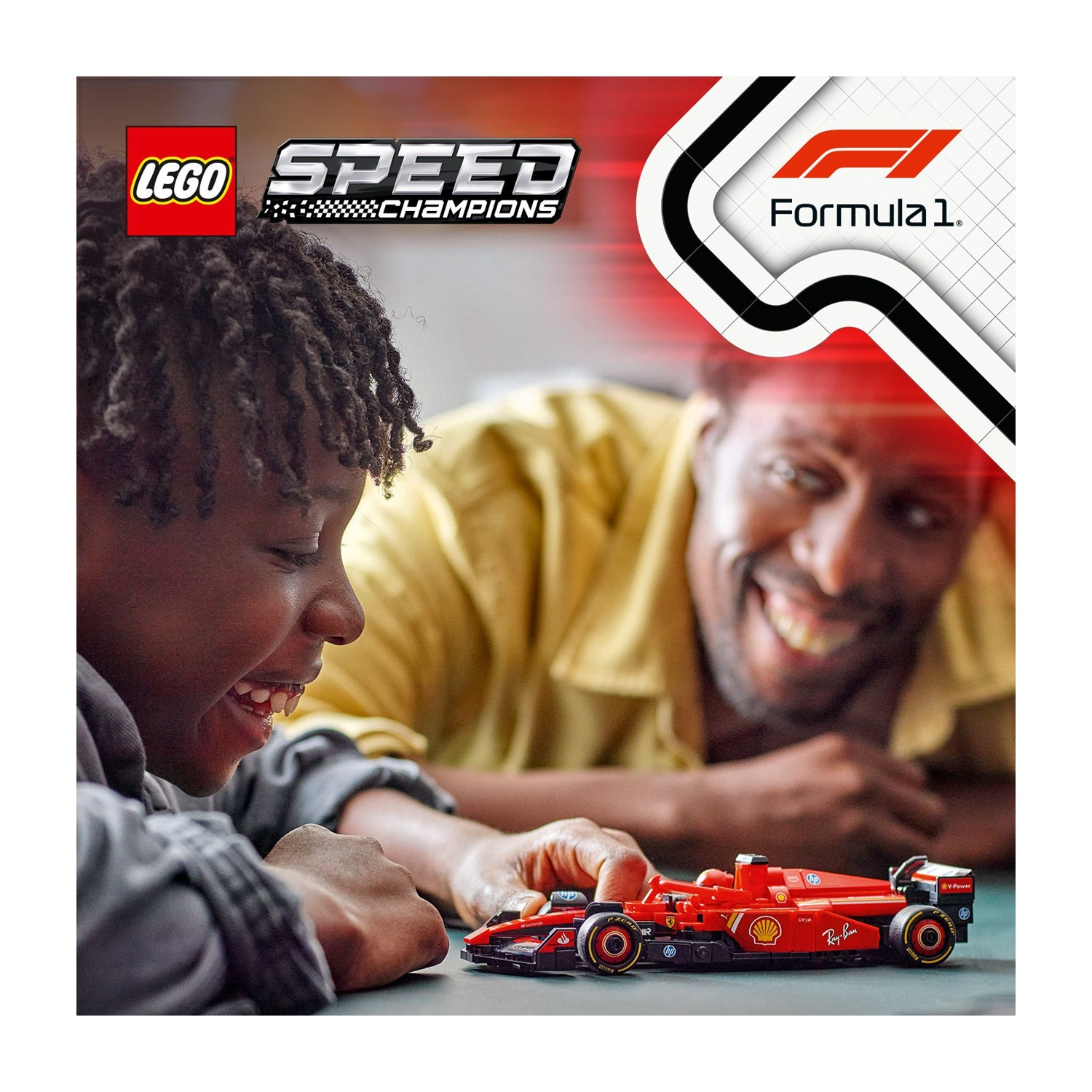 Un ragazzo e un uomo sorridenti giocano con una macchina di F1 Lego rossa. La scatola Lego e il logo Formula 1 sono sullo sfondo.