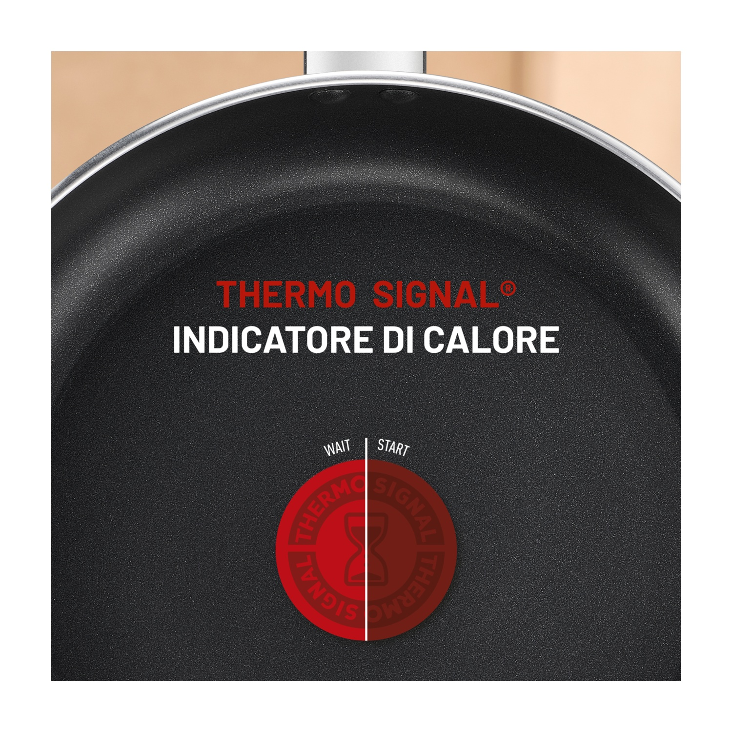 Primo piano di una padella nera con testo "Thermo Signal". Un indicatore rosso mostra lo stato del calore. Sfondo marrone.