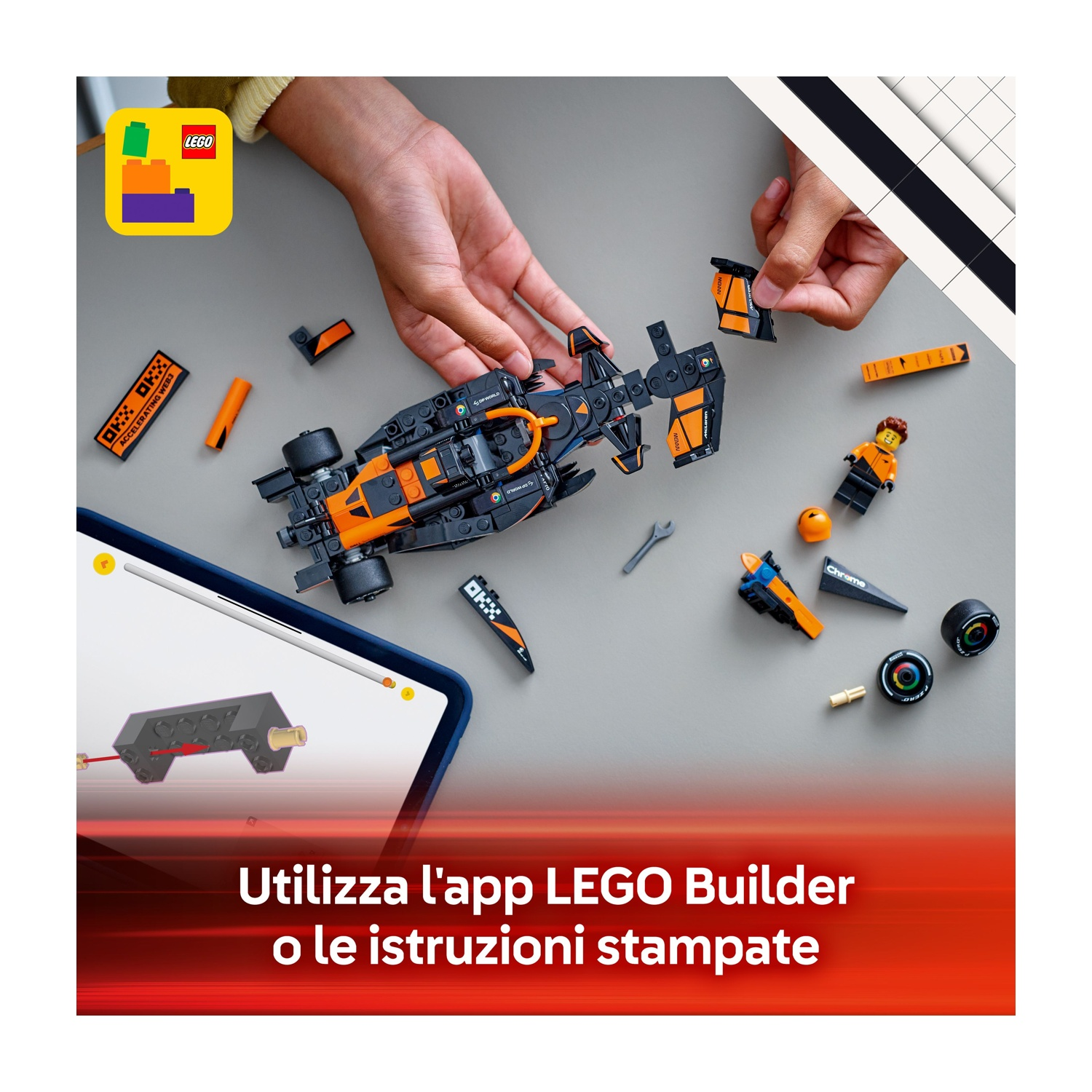 Mani assemblano un'auto da corsa Lego. Parti e strumenti sparsi su una superficie grigia. Tablet mostra le istruzioni. Il logo Lego è visibile.