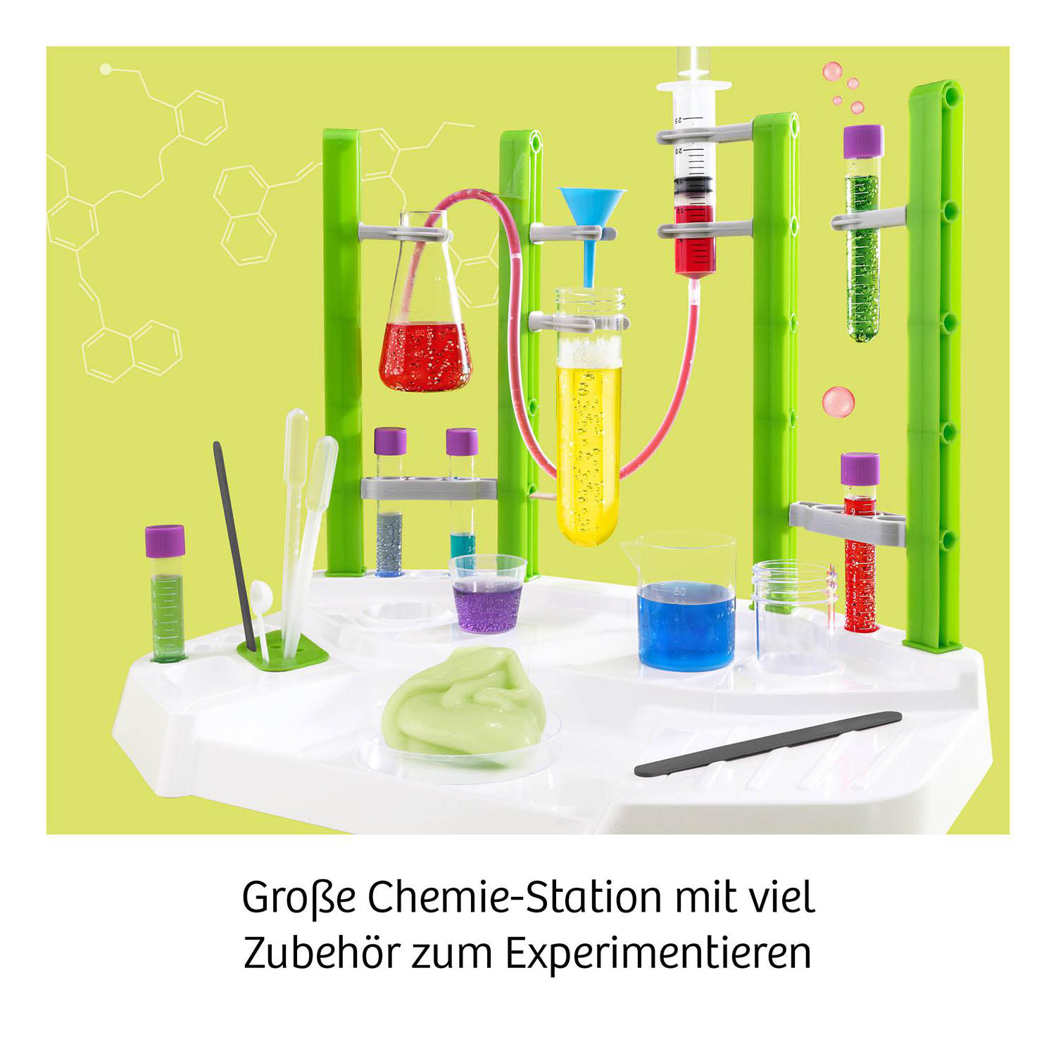 Ein Laboraufbau mit grünen Stützen, Reagenzgläsern mit farbigen Flüssigkeiten, Bechern und Schleim auf einer weißen Ablage.