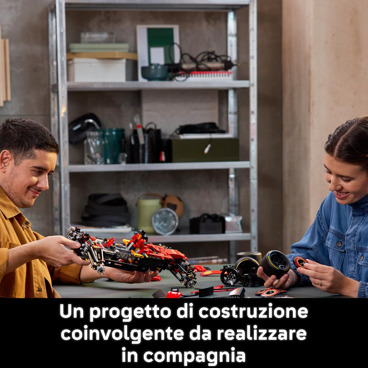 Due persone che costruiscono un'auto giocattolo rossa e nera. Parti e ruote sono sul tavolo. Scaffali con oggetti sullo sfondo.