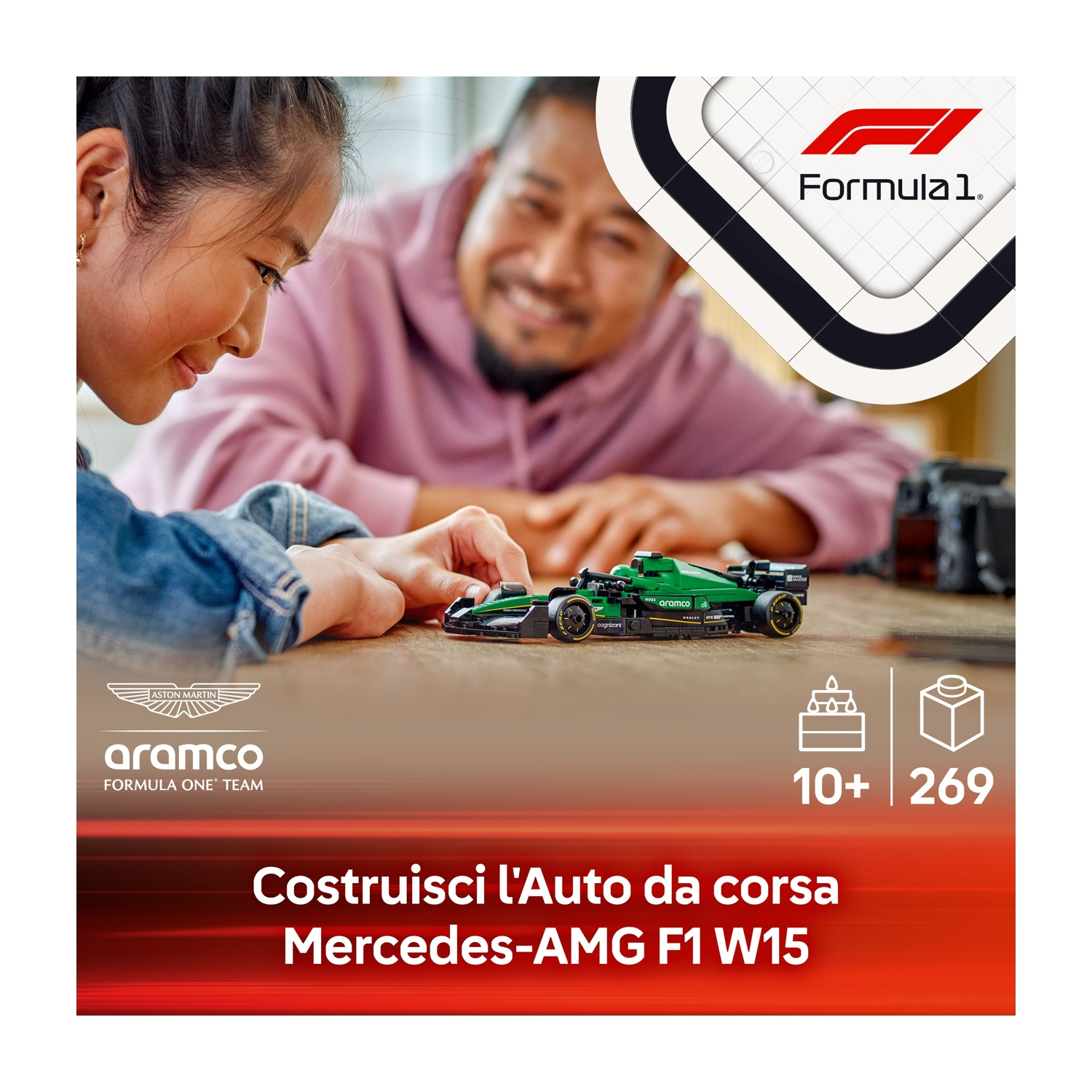 Un bambino e un adulto guardano un'auto da corsa giocattolo verde. L'auto è su una superficie di legno.