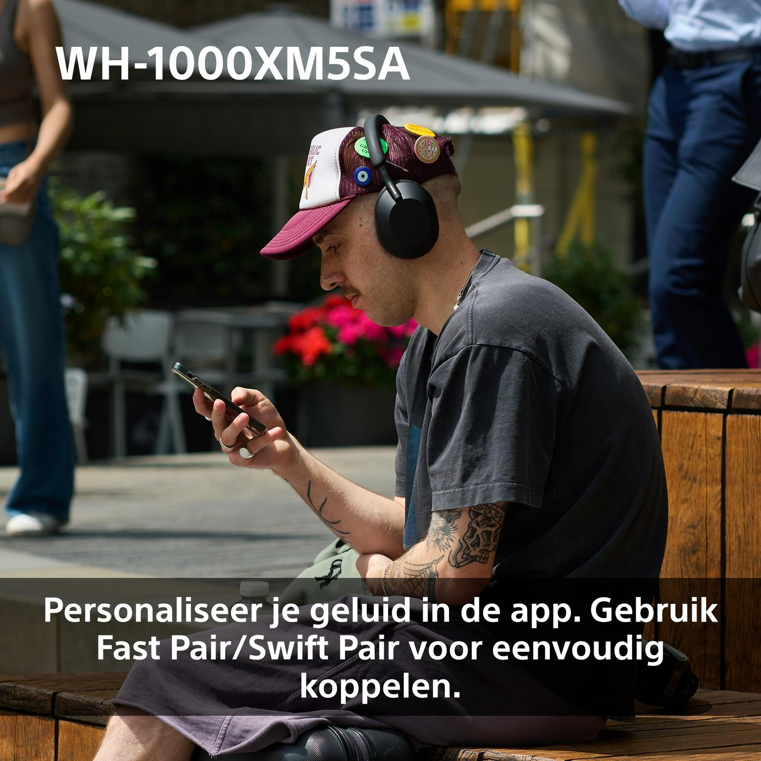 Een man met een koptelefoon en pet kijkt naar zijn telefoon. De tekst zegt: Personaliseer je geluid in de app. Gebruik Fast Pair/Swift Pair.