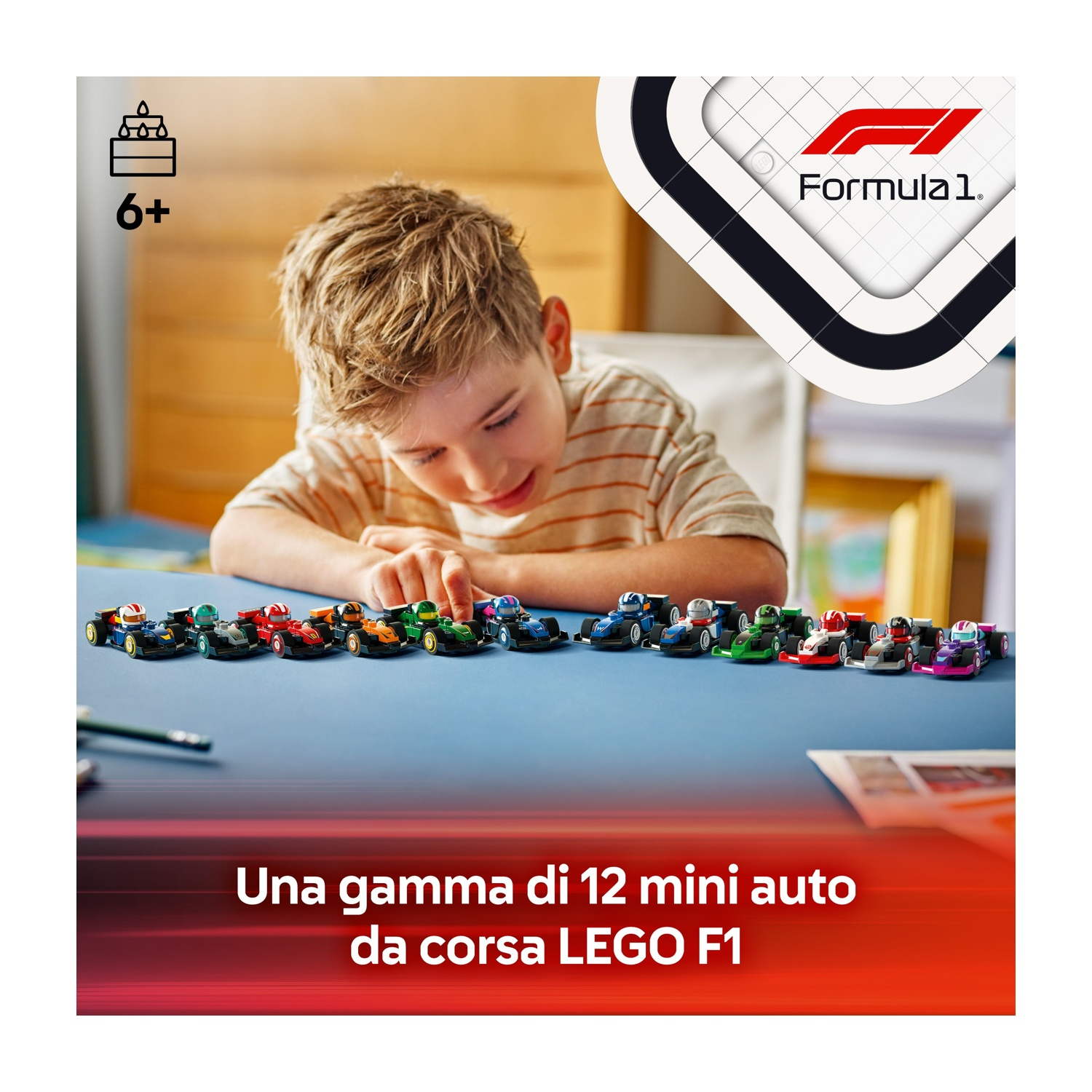 Un ragazzino guarda una fila di macchinine colorate su un tavolo blu. Logo Formula 1 visibile.