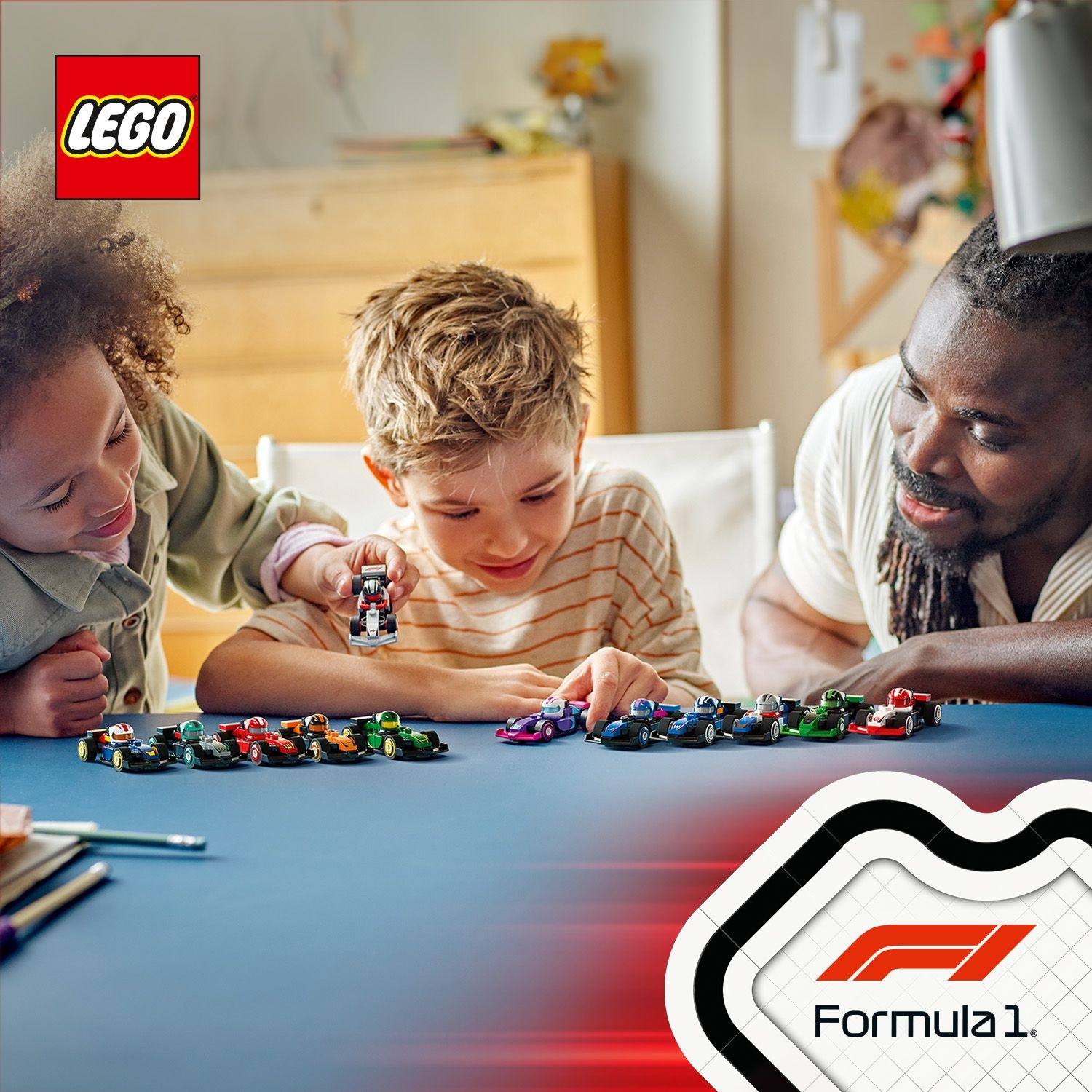Tre bambini e un adulto guardano delle macchinine Lego su un tavolo blu. I loghi Lego e Formula 1 sono visibili.