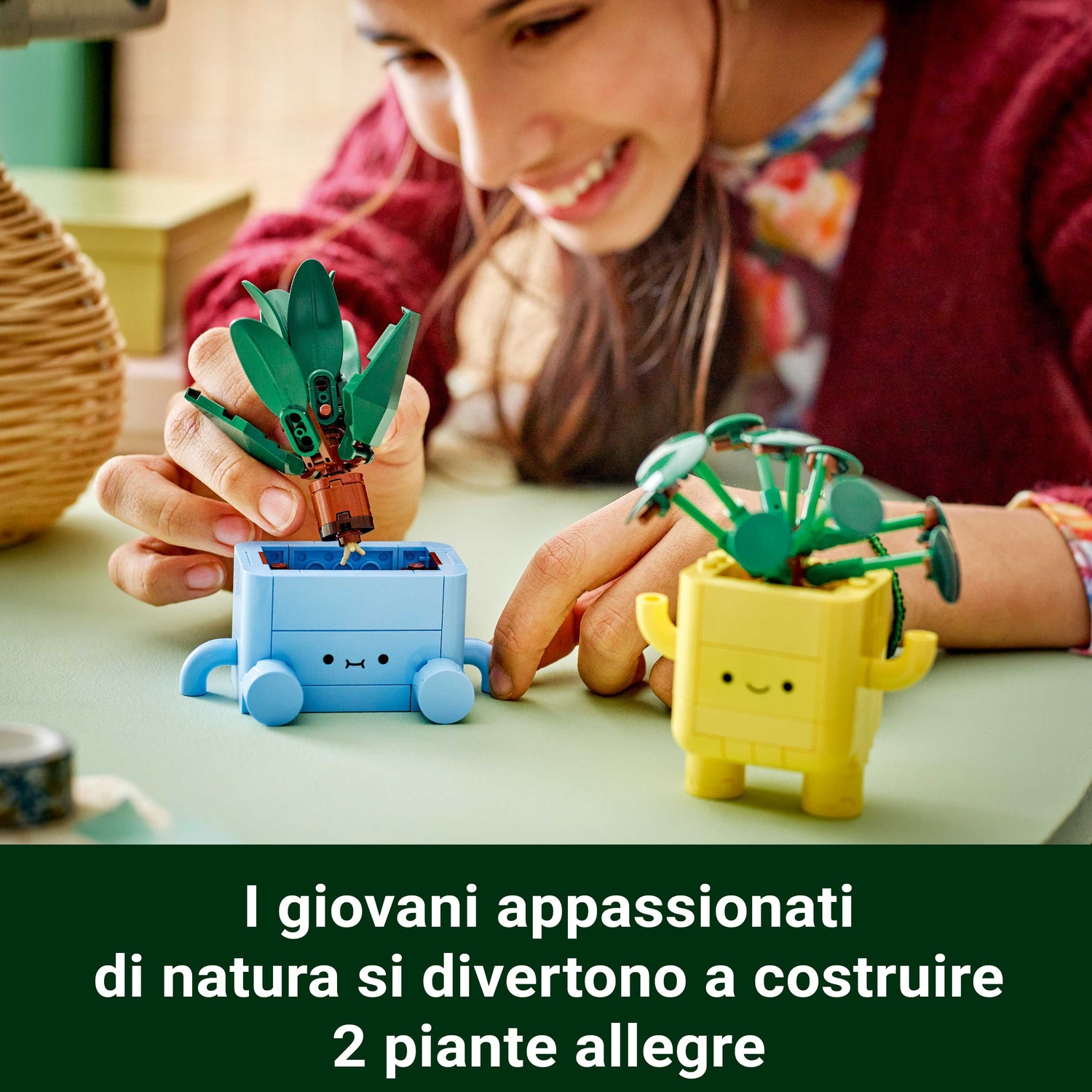 Una persona costruisce piante Lego. Una blu, una gialla. La persona sorride. Testo sotto: 'I giovani amanti della natura costruiscono 2 piante'.
