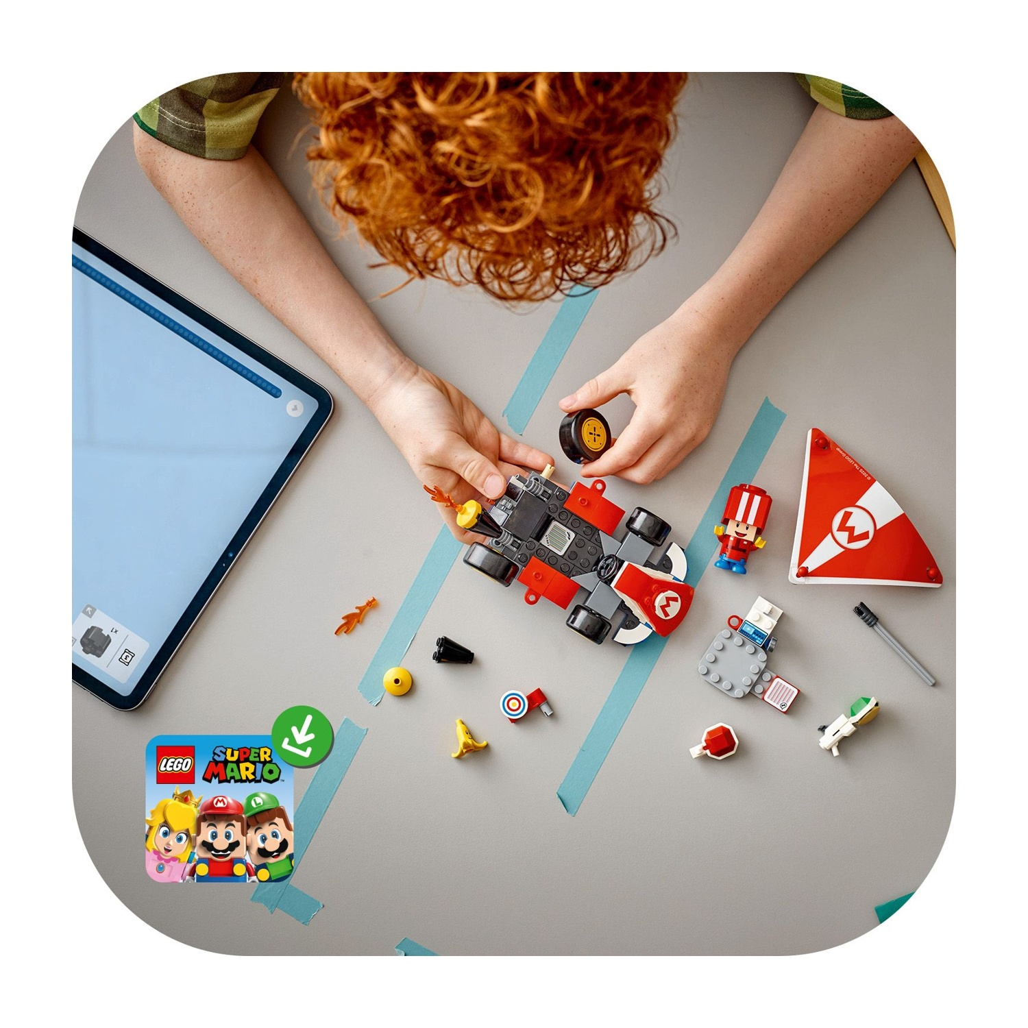 Una persona assembla un'auto Lego Mario su un tavolo. Sono visibili pezzi Lego e un tablet. La scena ha un tema Super Mario.