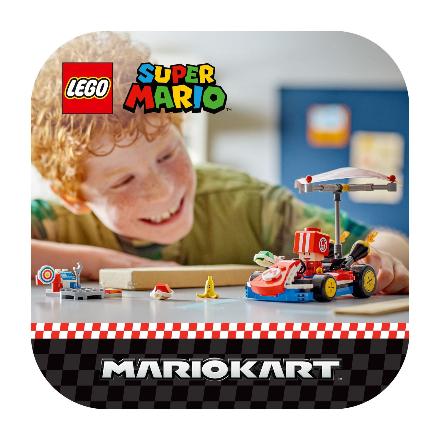 Un bambino sorride a un set Lego Mario Kart. Il set include un kart, un bersaglio e altri accessori. Il logo Lego è visibile.