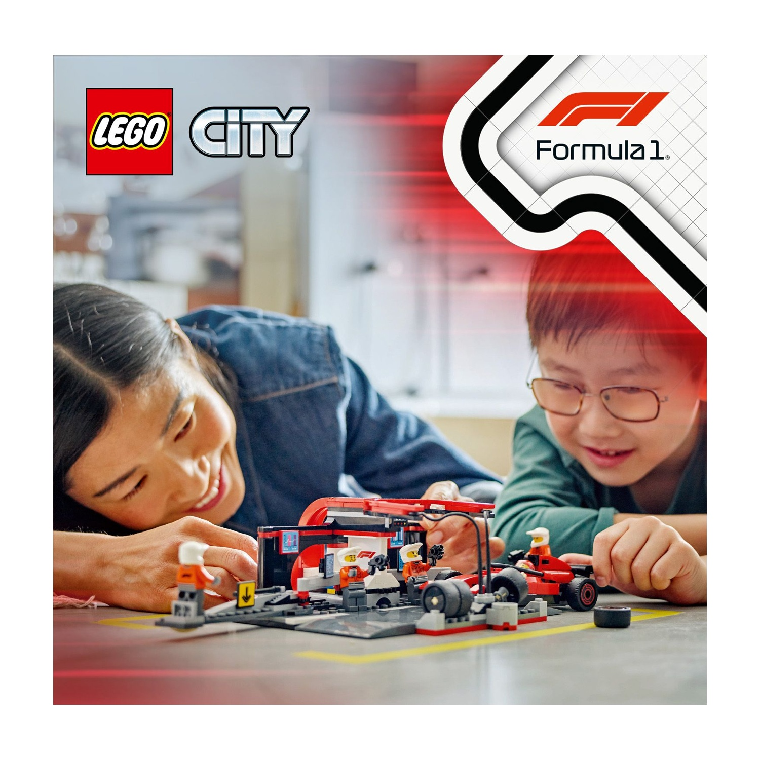 Una donna e un bambino giocano con un set Lego City Formula 1. Il set include un'auto da corsa rossa e un garage.