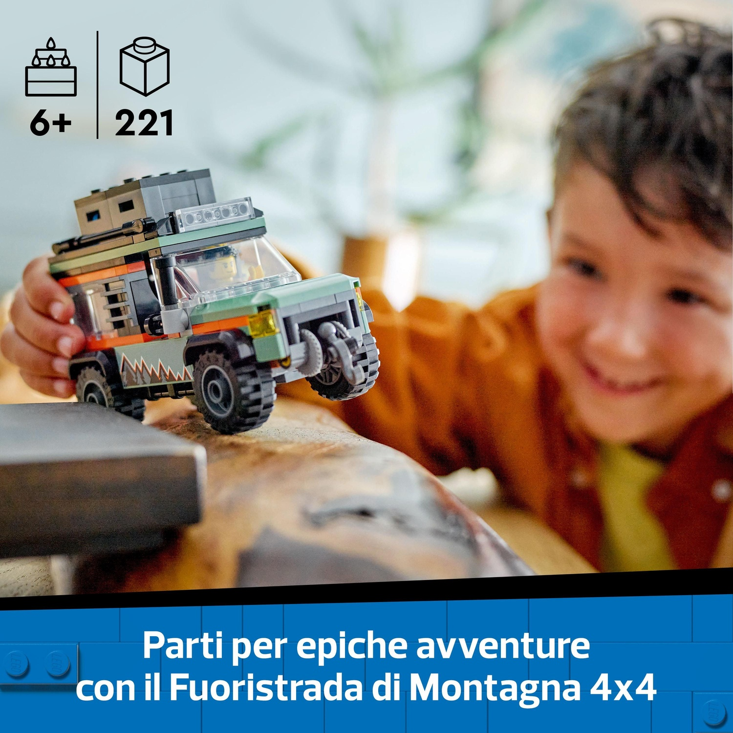 Un bambino tiene in mano un veicolo fuoristrada LEGO. Il veicolo è verde e arancione. Il bambino sorride. Sullo sfondo ci sono icone LEGO.