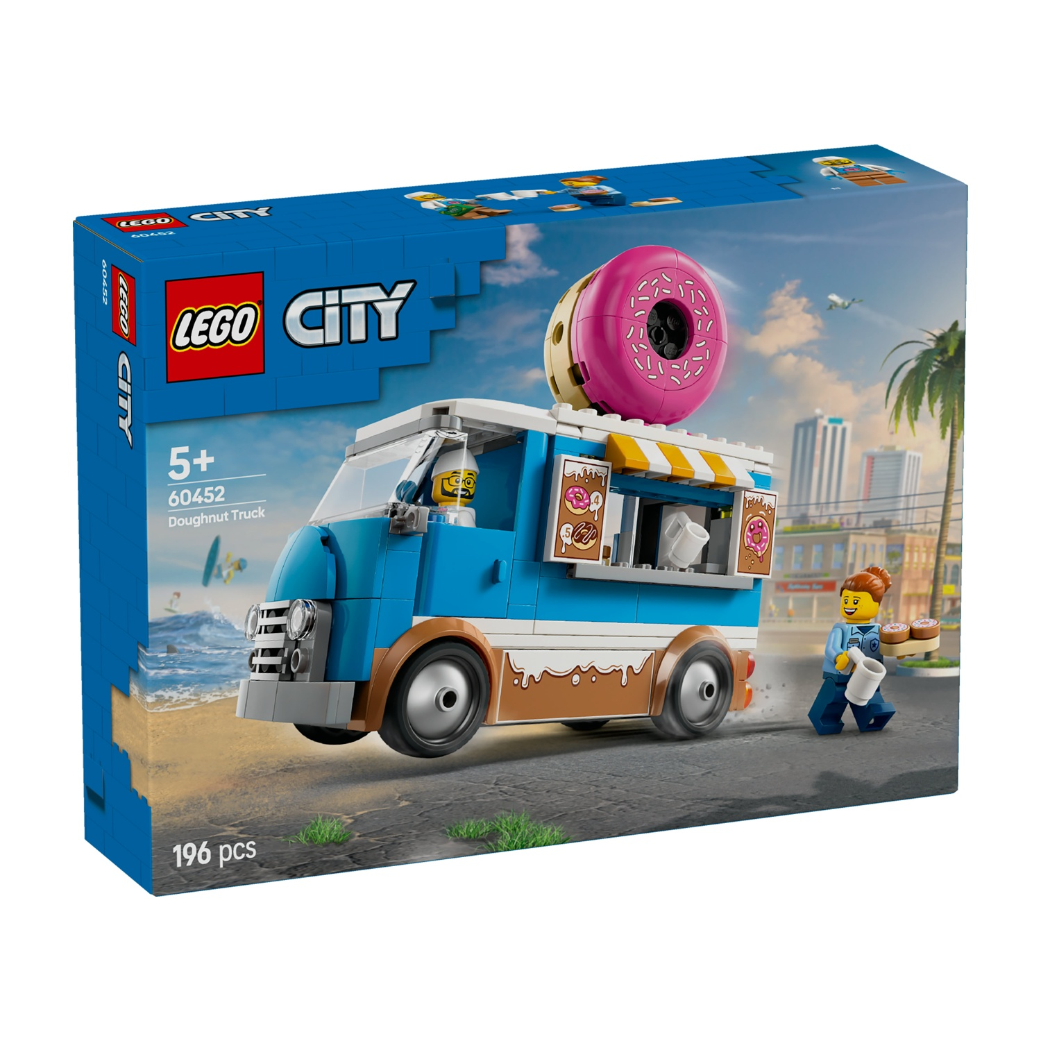 Scatola del camioncino di ciambelle Lego City. Il camion blu ha una grande ciambella rosa sopra. Una minifigure vende ciambelle. Lo sfondo è una scena di spiaggia.