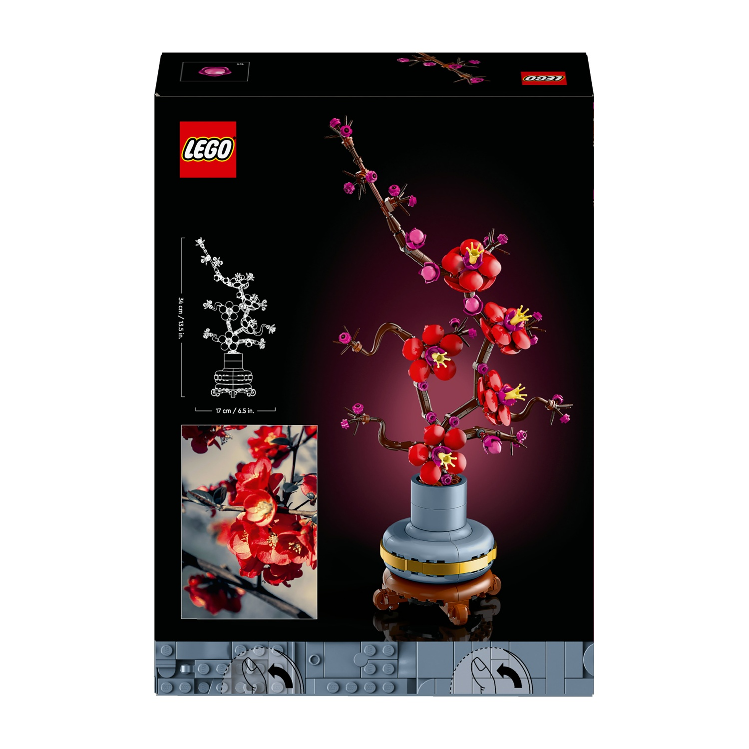 Una scatola LEGO con la costruzione di un albero di fiori di ciliegio. Ha fiori rossi, rami marroni e un vaso grigio su un supporto marrone.