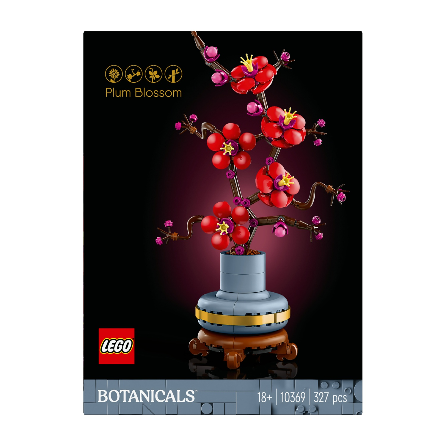 Un set Lego di fiori di prugno. Fiori rossi con centri gialli su rami marroni. Il vaso è blu con finiture dorate, su un supporto marrone.