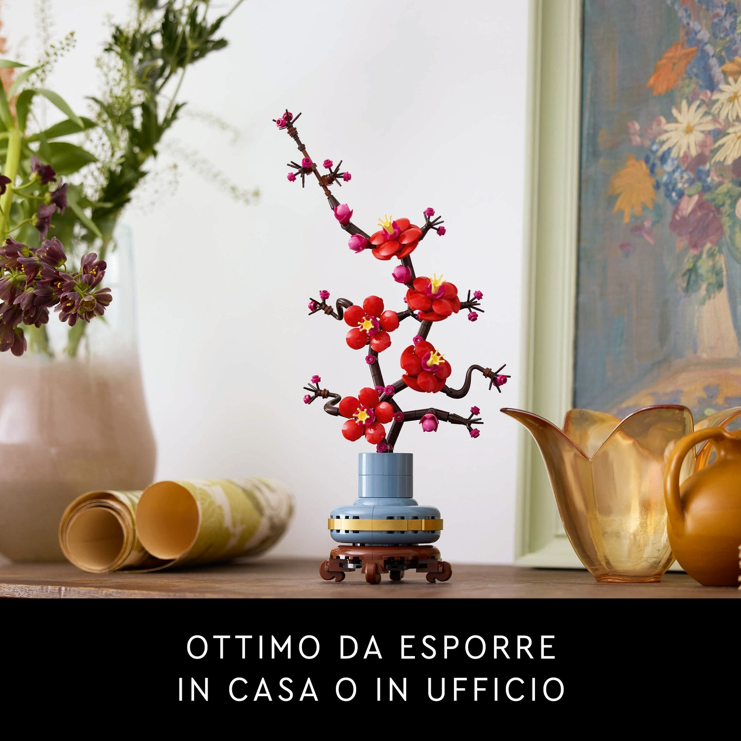 Un'arrangiamento floreale Lego con fiori rossi e un vaso blu. Altri fiori e opere d'arte sullo sfondo. Il testo dice 'Ottimo da esporre'.