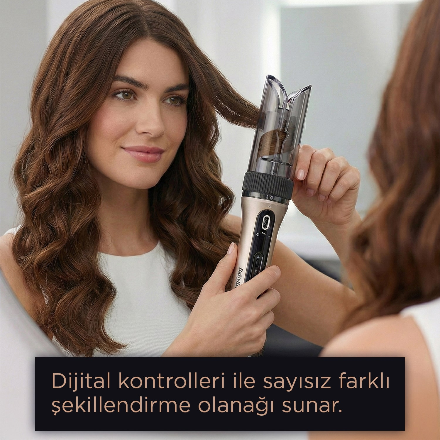 Bir kadın saç kıvırma aleti kullanıyor, aynaya bakıyor. Uzun kahverengi saçları ve beyaz bir üst giyiyor. Metin siyah bir kutuda.