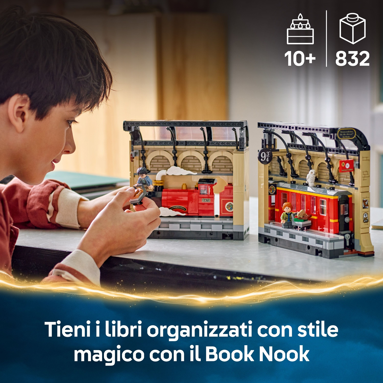 Un ragazzo costruisce un set Lego di una stazione ferroviaria. Due stazioni ferroviarie Lego sono su un tavolo. Il set include un treno e delle figure.
