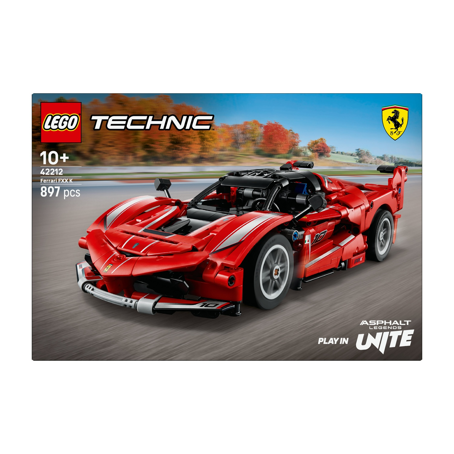 È mostrato un modello Lego Technic Ferrari FXX K. L'auto rossa è su una strada con sfondo di cielo blu e alberi autunnali.