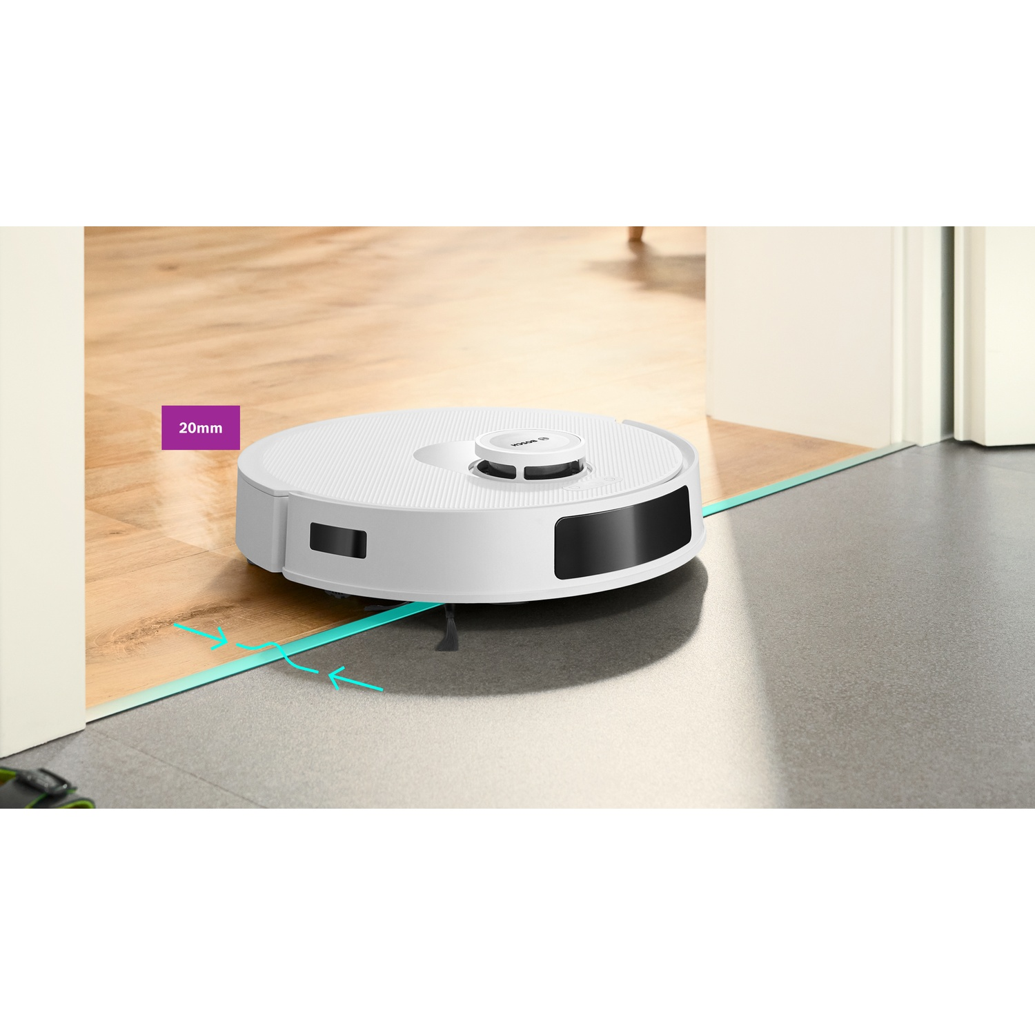 Een witte robotstofzuiger op de vloer, die overgaat van houten vloer naar grijze tegels. Pijlen en tekst geven een hoogteverschil van 20 mm aan.